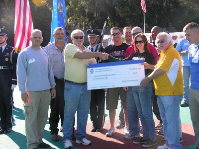 Lt. Col. White 437th Maintenance Squadron commander and Master Sgt. Jennifer Crerar, 16th Airlift Squadron first sergeant (center) present a check for $500 to members of the Summerville Miracle League Nov. 2, 2012, in Summerville, S.C. (U.S. Air Force photo/ Senior Airman Adrian Welch)
