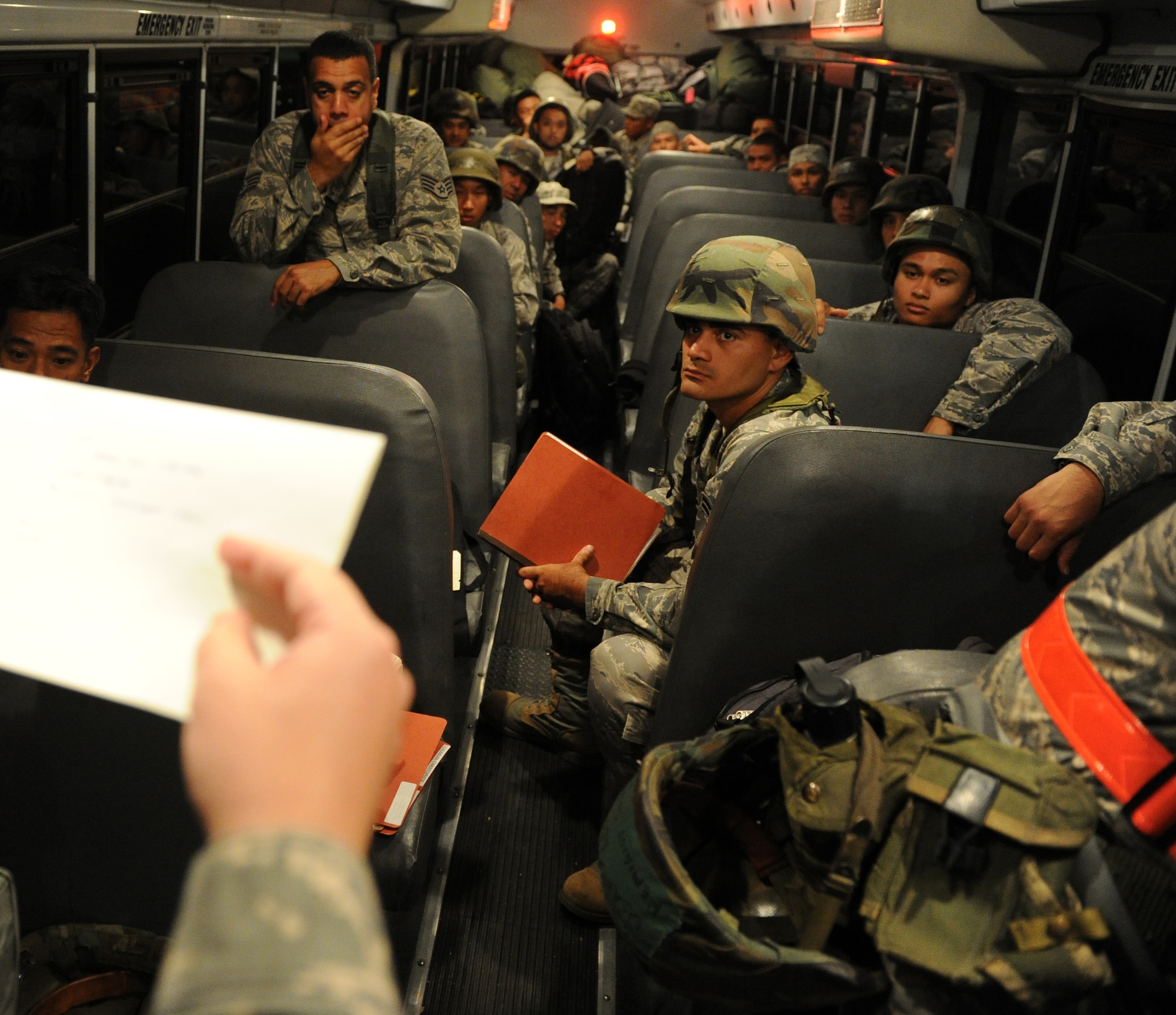 Airmen from the Hawaii Air National Guard receive a "bus brief" before processing through a personnel deployment function line Nov. 7 during an exercise at Joint Base Pearl Harbor-Hickam, Hawaii. The PDF line tests the ability of Airmen to be medically, legally, administratively, spiritually, and financially ready to deploy, as well as the functionality of the processes in place with which to deploy them. (U.S. Air Force photo by Staff Sgt. Nathan Allen)