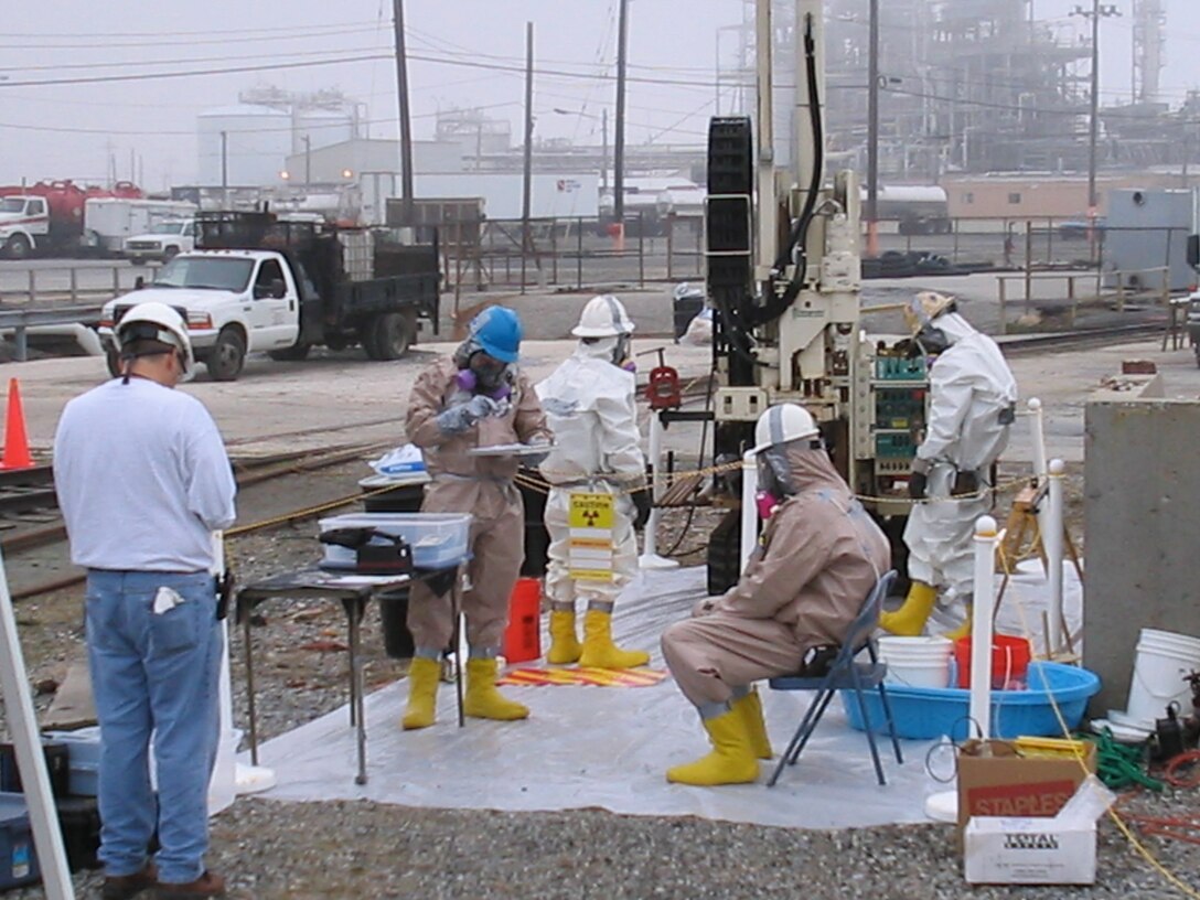 The U.S. Army Corps of Engineers Philadelphia District supports FUSRAP remediation efforts at DuPont Chambers Works in Pennsville, NJ. Workers in the exclusion zone sample soil with support personnel nearby. 