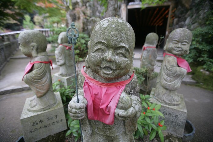 A circle of Jizo statues stand wearing red bibs at the Itsukushima Shrine. According to Japanese folklore red is the color which symbolizes expelling demons and illness. The statues can be found is different poses across Itsukushima.