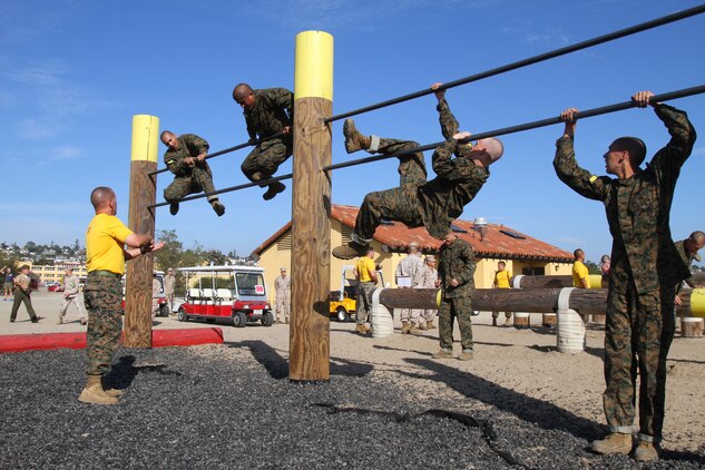 Recruits of Company H, 2nd Recruit Training Battalion, climb over a set of bars during the obstacle course aboard Marine Corps Recruit Depot San Diego Nov. 1. The portion of the course required recruits to maneuver over the top bar, by using the bottom bar as support.