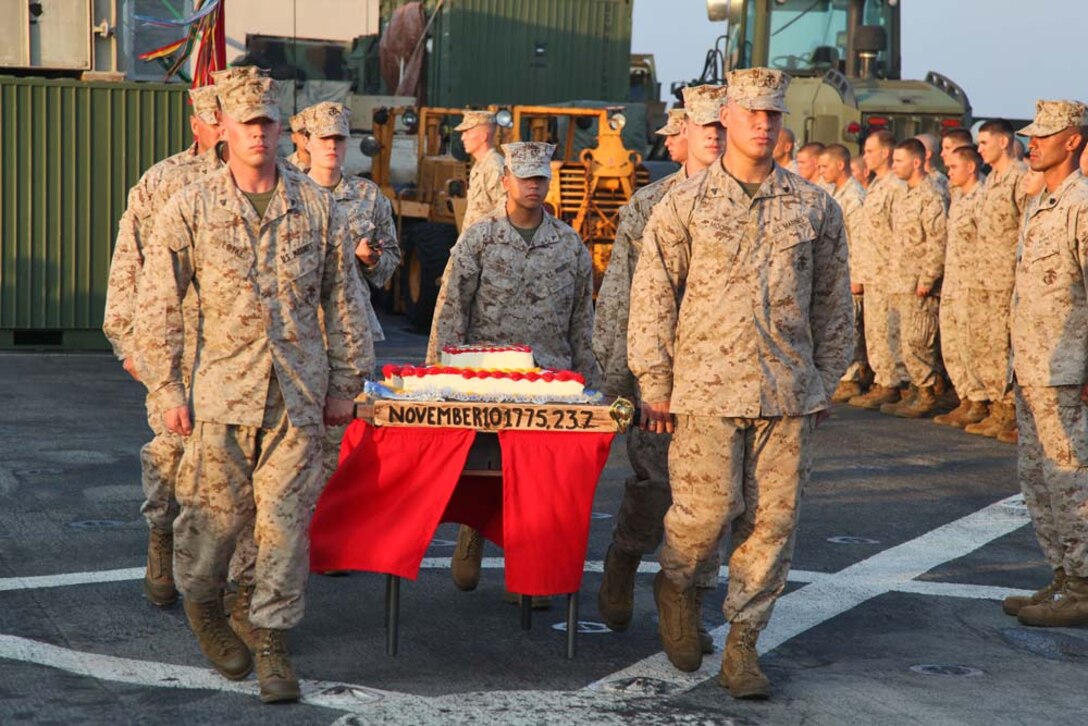 Marines from the 15th Marine Expeditionary Unit carry the ceremonial birthday cake during an early Marine Corps Birthday celebration on the flight deck of the USS Rushmore, Nov. 7. The 15th MEU is deployed as part of the Peleliu Amphibious Ready Group as a theater reserve and crisis response force throughout U.S. Central Command and the U.S. 5th Fleet area of responsibility.