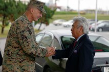 Col. John E. Kasperski welcomes Urasoe City Mayor Mitsuo Gima aboard Camp Kinser during a tour of the camp Nov. 5. Kasperski is the Camp Kinser camp commander and the commanding officer of Combat Logistics Regiment 37, 3rd Marine Logistics Group, III Marine Expeditionary Force.