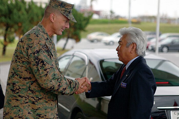 Col. John E. Kasperski welcomes Urasoe City Mayor Mitsuo Gima aboard Camp Kinser during a tour of the camp Nov. 5. Kasperski is the Camp Kinser camp commander and the commanding officer of Combat Logistics Regiment 37, 3rd Marine Logistics Group, III Marine Expeditionary Force.