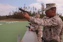 Lance Cpl. Eric Zamora fires a pistol at Camp Hansen Oct. 29 during combat marksmanship training. The purpose of the training is to develop range coaches’ ability to teach marksmanship fundamentals to other Marines following a weeklong period of classroom instruction. “The Marines have to shoot the weapon to fully comprehend what they have learned,” said Sgt. Argus R. Bennett, a CMT instructor and radio operator with Combat Logistics Regiment 3, 3rd Marine Logistics Group. Zamora is a warehouse clerk with CLR-35, 3rd MLG.