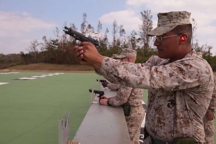 Lance Cpl. Eric Zamora fires a pistol at Camp Hansen Oct. 29 during combat marksmanship training. The purpose of the training is to develop range coaches’ ability to teach marksmanship fundamentals to other Marines following a weeklong period of classroom instruction. “The Marines have to shoot the weapon to fully comprehend what they have learned,” said Sgt. Argus R. Bennett, a CMT instructor and radio operator with Combat Logistics Regiment 3, 3rd Marine Logistics Group. Zamora is a warehouse clerk with CLR-35, 3rd MLG.