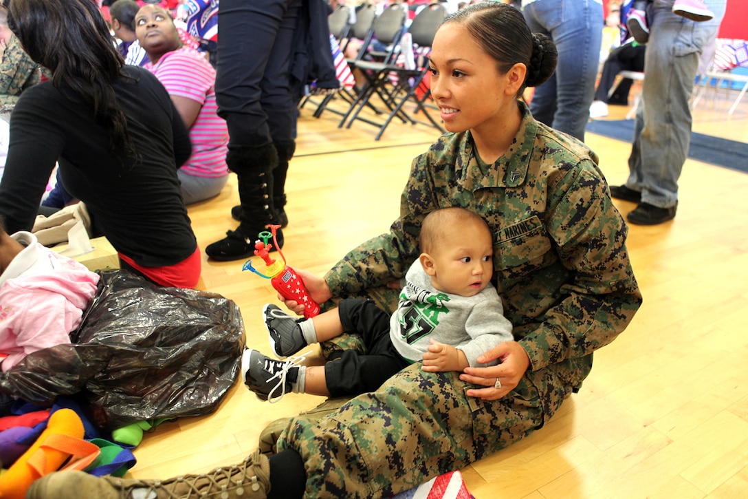 Cpl. Jessa Monroa, an aviation supply specialist with Marine Aircraft Group 31, holds her son Jayden while enjoying The Sesame Street/ USO Experience for Military Families at the Marine Corps Air Station Beaufort fitness center, Nov. 6. The exclusive live performance feautured characters from Sesame Street to help children relate and cope with the challenges that coincide military lifestyle.