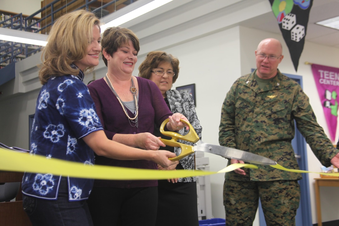 Becky Cederholm, spouse of Col. Michael Cederholm, the commanding officer for Marine Aircraft Group 31, and Karen Murtha, spouse of Col. Brian Murhta, commanding officer of Marine Corps Air Station Beaufort, cut the ribbon at a dedication ceremony for the First Lady of the Marine Corps reading list section at the Air Station Library, Nov. 8.