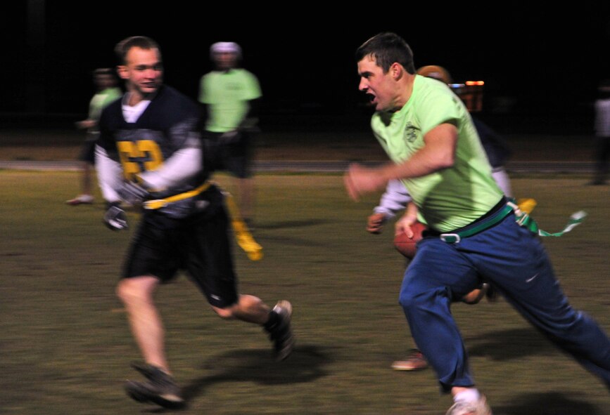 The quarterback from the 336th Training Group team runs the ball down the field during the intramural football championship game, Nov. 7, 2012. The game was tied up by the end of the fourth quarter; the 92nd Maintenance Squadron team kicked a field goal to win. The final score ended at 17-14. (U.S. Air Force photo by Airman 1st Class Taylor Curry)