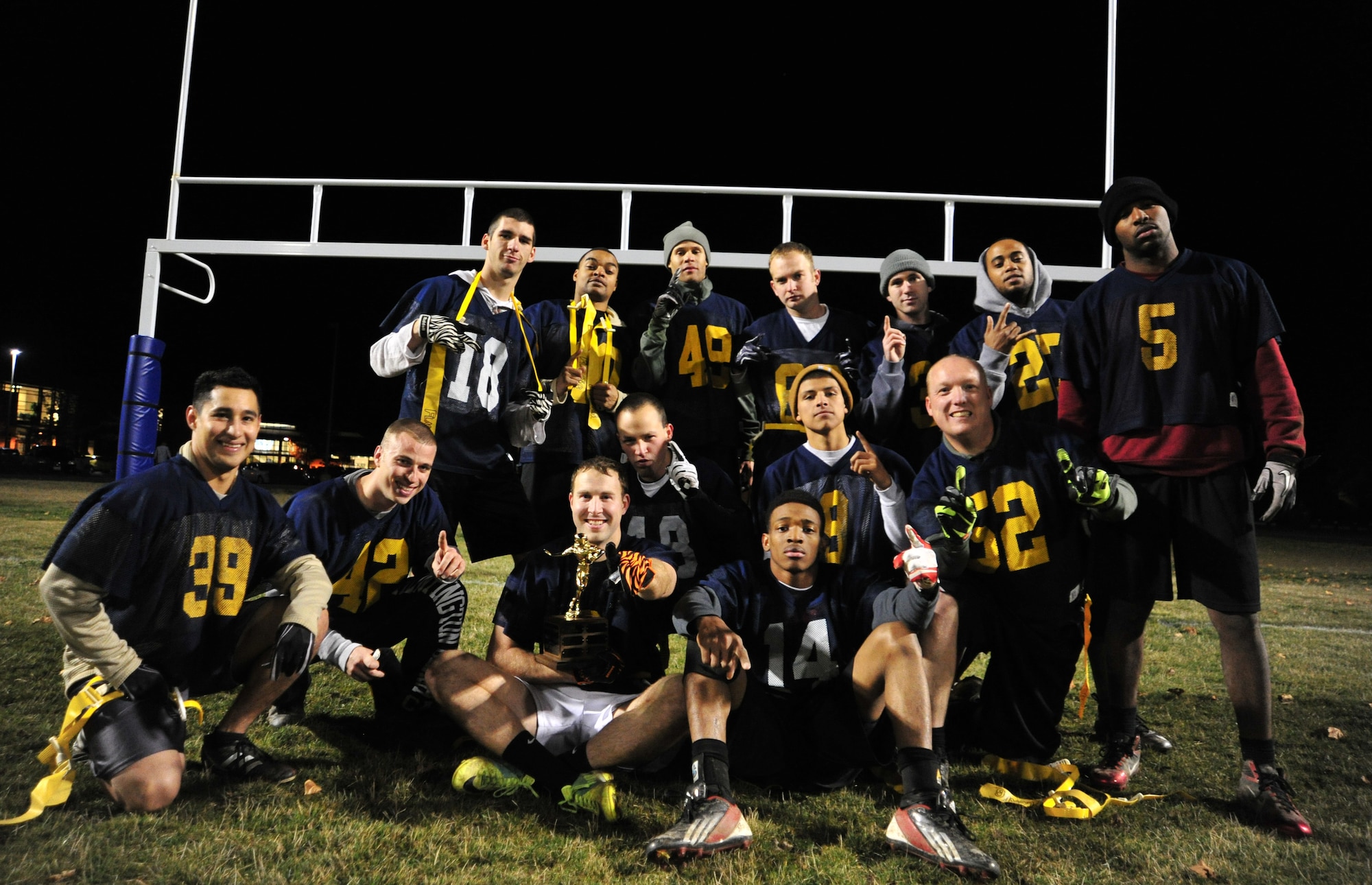 The 92nd Maintenance Squadron football team members pose for a photo after winning the intramural football season championship game against the 336th Training Group team, Nov. 7, 2012. The game was tied up by the end of the fourth quarter; the maintenance team kicked a field goal to win. The final score ended at 17-14. (U.S. Air Force photo by Airman 1st Class Taylor Curry)
