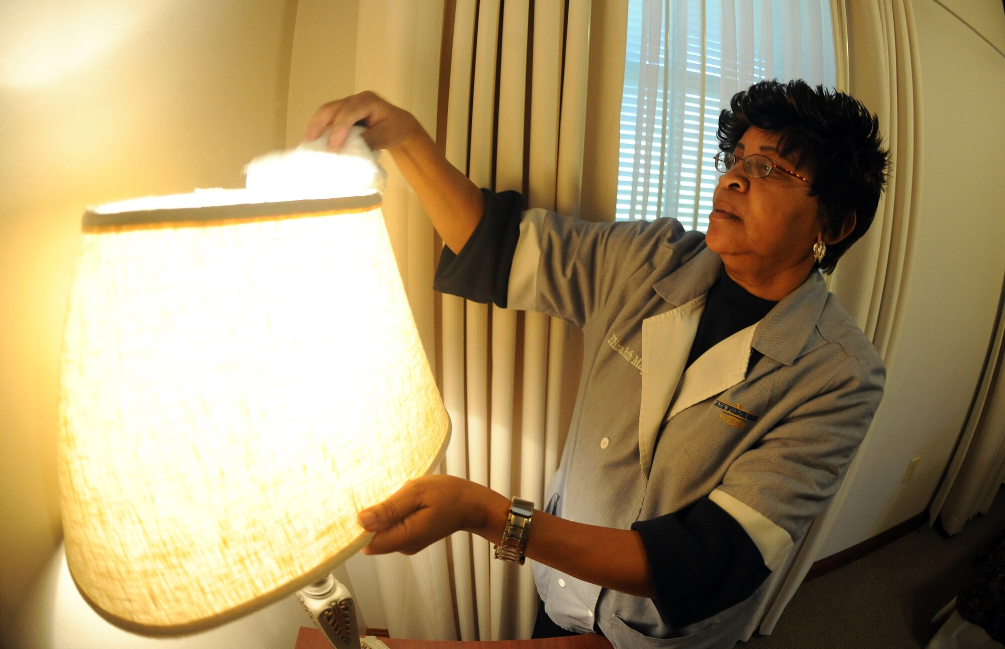 Elizabeth Mays, 2nd Force Support Squadron housekeeping, wipes down the top of a lampshade on Barksdale Air Force Base, La., Nov. 8. The Barksdale Inn has 263 rooms available in eight different buildings for occupants to enjoy. The inn also accommodates travelers with pets. (U.S. Air Force photo/Senior Airman Micaiah Anthony)(RELEASED)