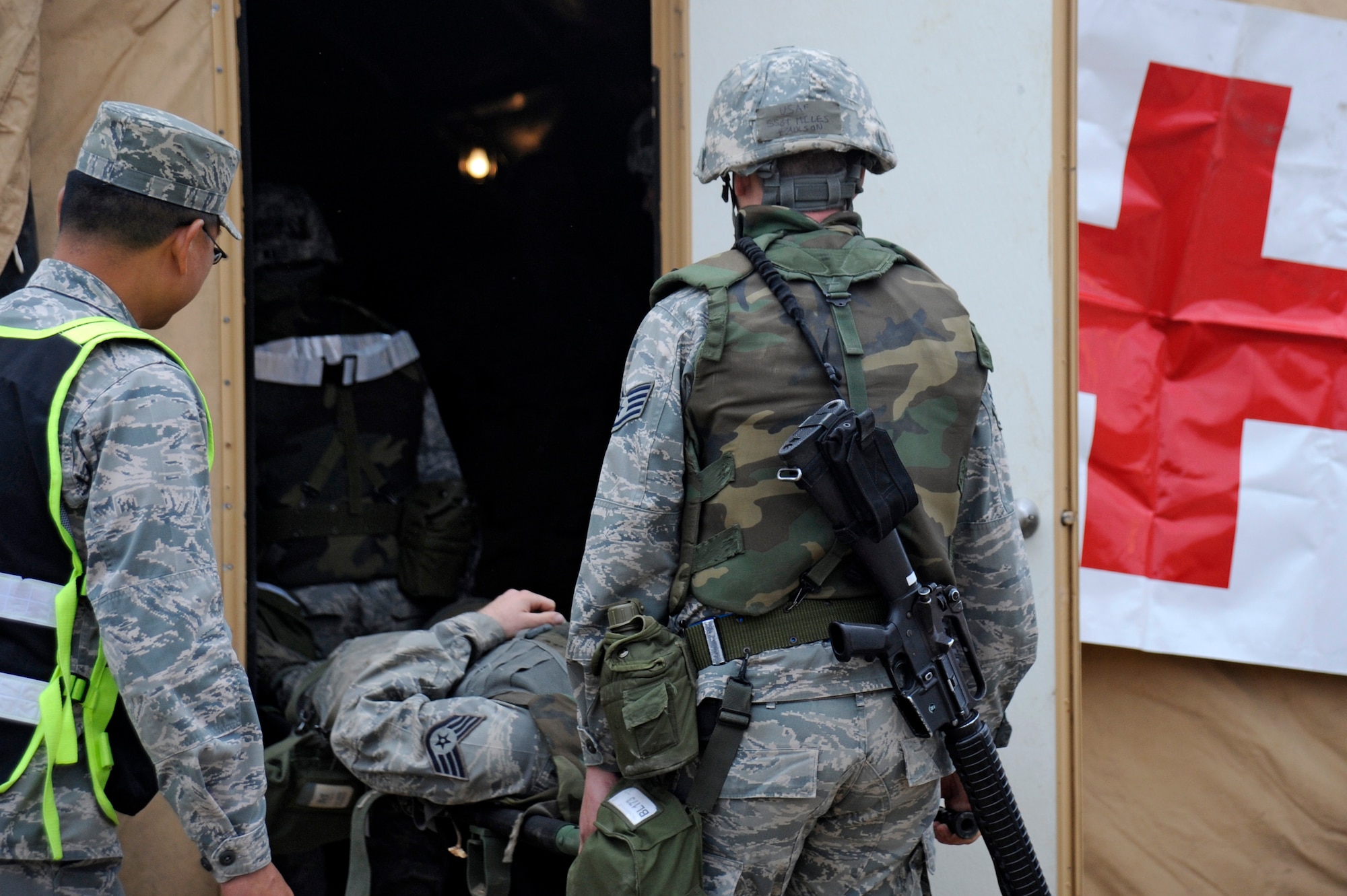 VANDENBERG AIR FORCE BASE, Calif. -- 
Staff Sgt. Miles Paulson, 30th Logistics Readiness Squadron member, helps carry a wounded Airmen into the medical tent as an exercise evaluator observes during a Northstar exercise Thursday, Nov 8., 2012. The Northstar exercise is designed to test the deployment capabilities and combat survival skills of Vandenberg Airmen. (U.S. Air Force photo/Michael Peterson)