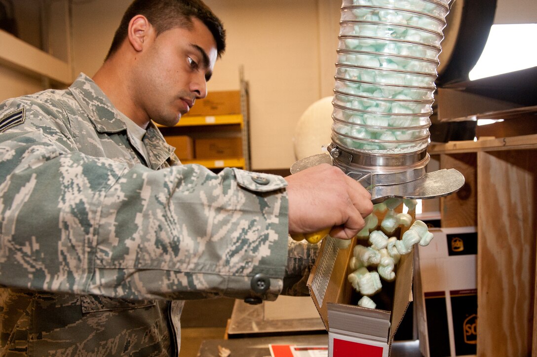 Senior Airman Josue Diaz, 28th Logistics Readiness Squadron packing and crating technician, fills a box containing an aircraft part with styrofoam peanuts before shipping it in the packing and crating shop at Ellsworth Air Force Base, S.D., Nov. 2, 2012. Diaz filled the box with packing peanuts to cushion the part so it would remain undamaged during shipment. (U.S. Air Force photo by Airman 1st Class Kate Thornton-Maurer/Released)
