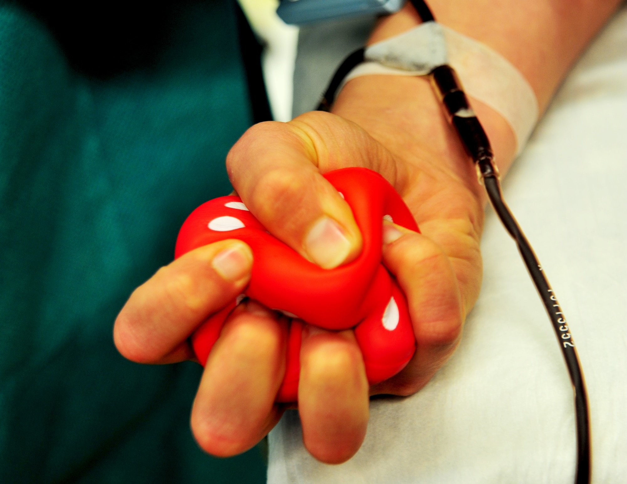 U.S. Air Force Airman 1st Class Tiffany Stegner, 27th Special Operations Communication Squadron Airfield Systems technician, squeezes a die while having her blood drawn for the Armed Services Blood Program at the Chapel at Cannon Air Force Base, N.M., Nov. 6, 2012. The ASBP is an inter-service operation that provides quality blood products for service members and their families in both peace and war. (U.S. Air Force photo/Senior Airman Whitney Tucker)
