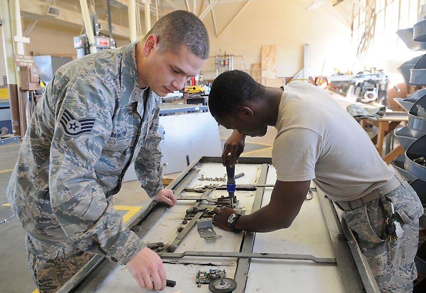 Staff Sgt. Anthony Barrow and Airman 1st Class Tevin Tolver, 2nd Civil Engineer Squadron Structures flight, repair an XO7 lock on a vault door on Barksdale Air Force Base, La., Nov. 8. Airmen from the structures shop are trained on a variety of construction related skills such as welding, carpentry, masonry, painting, sheet-metal fabrication and locksmithing. (U.S. Air Force photo/ Senior Airman Kristin High)(RELEASED)

