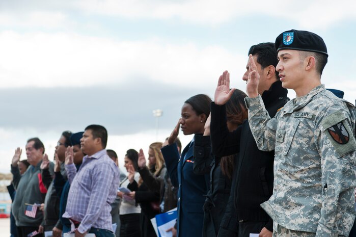 U.S. Army Pfc. Heber Pereira, 63rd Brigade Support Battalion communications specialist, repeats the United States Oath of Allegiance alongside other newly naturalized U.S. citizens during a naturalization ceremony Nov. 9, 2012, at Nellis Air Force Base, Nev. Twenty five individuals obtained U.S. citizenship at the ceremony. (U.S. Air Force photo by Airman 1st Class Jason Couillard)