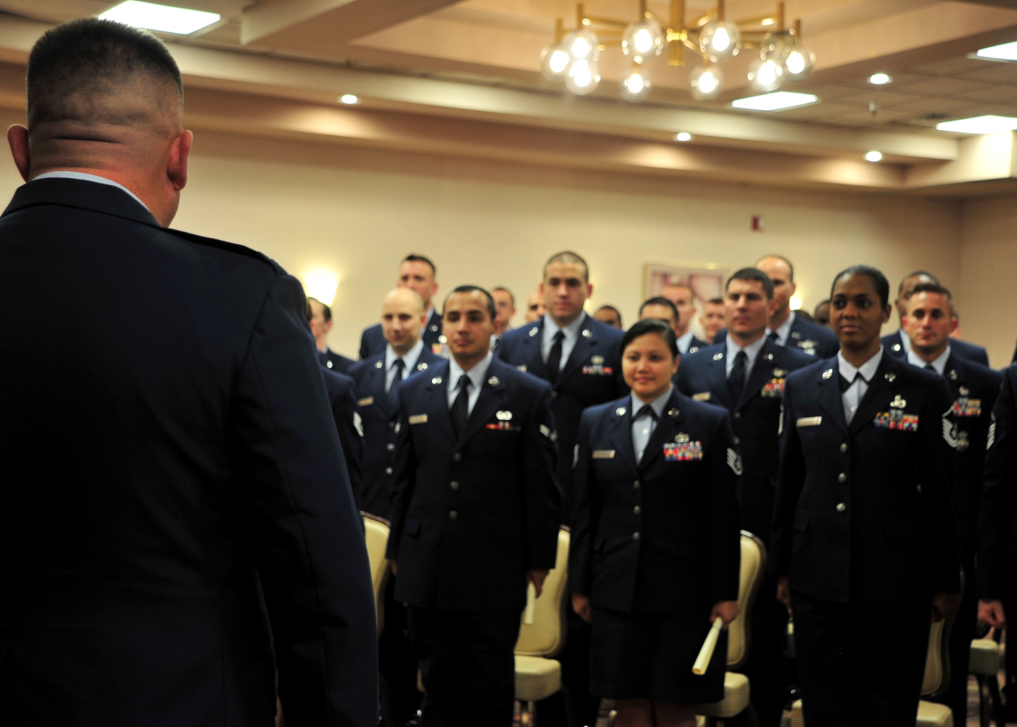 Airmen assigned to the 27th Special Operations Wing at Cannon Air Force Base, N.M., stand while Col. Craig Walker, 27 SOW vice commander, confers their degrees from the Community College of the Air Force at The Landing Zone, Nov. 8, 2012. The CCAF offers enlisted Airmen an opportunity to earn an associate of applied science degree or a professional certification certificate in one of several fields of study. (U.S. Air Force photo/Senior Airman Whitney Tucker)