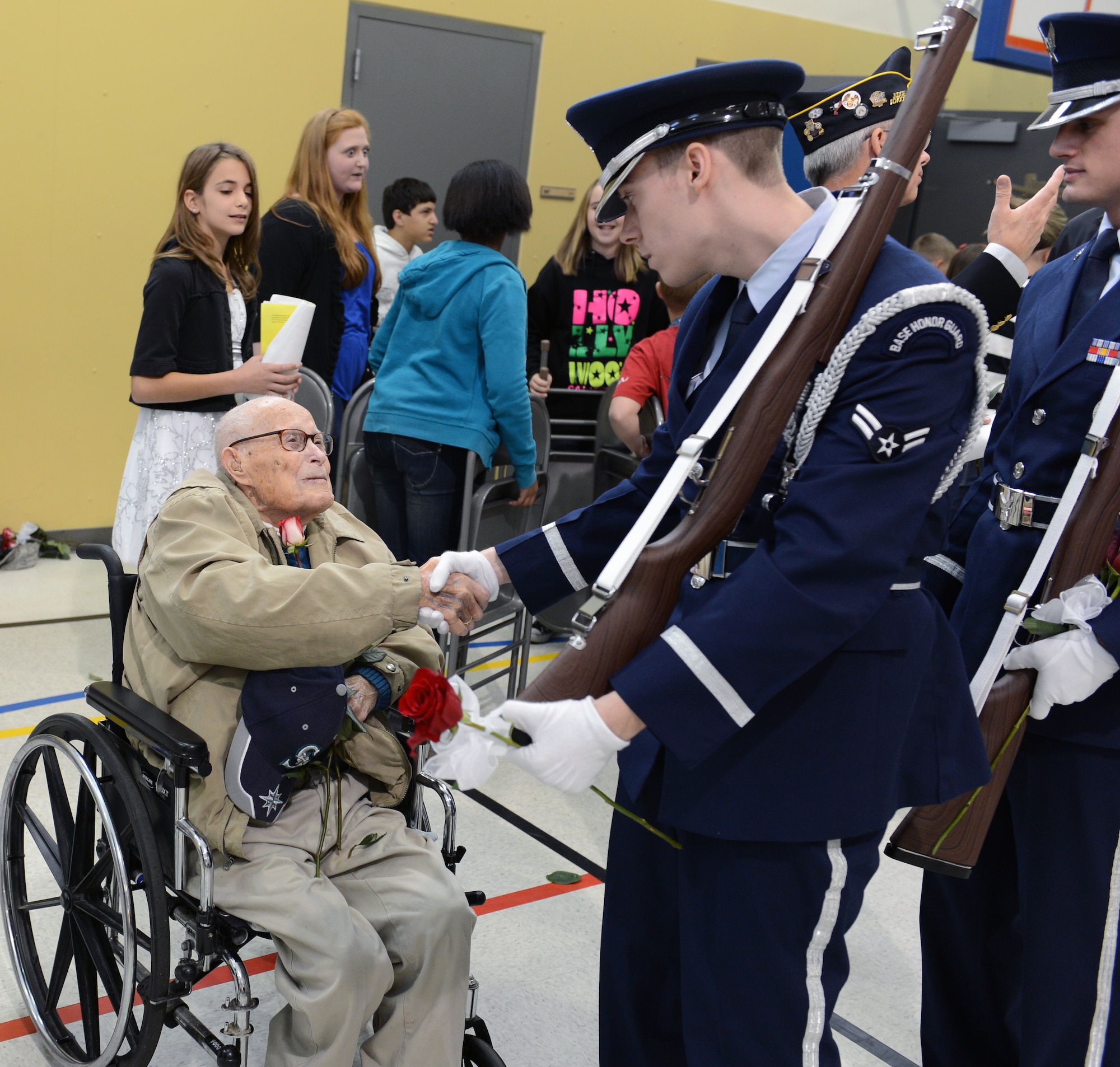 Airman 1st Class Kyle Martin and Senior Airman John Krook, McChord Field Honor Guard members, assigned to Joint Base Lewis-McChord, Wash., shake hands with World War II veteran Joseph Fox after the Meeker Elementary School Veterans Day assembly, Nov. 8, 2012 at Puyallup, Wash. Fox is more than 102 years old and served 27 years in the military. (U.S. Air Force photo/Master Sgt. Todd Wivell)