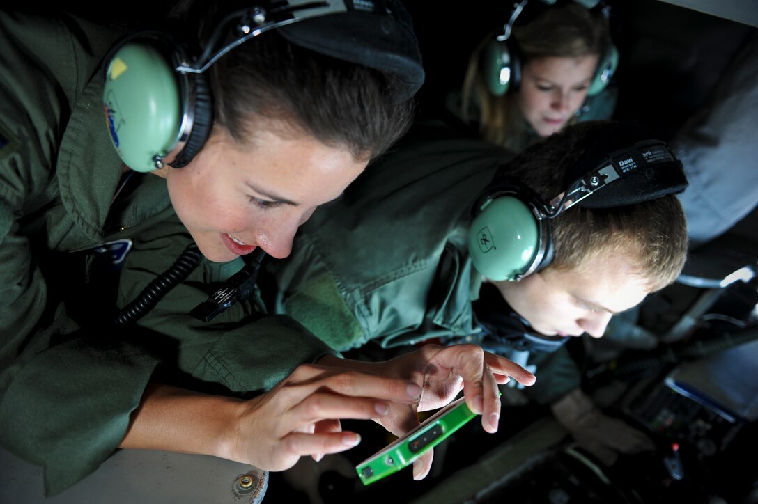 Senior Airman Jonathan Mellon shows Ann Gottlieb and Amy Reeves how to refuel a KC-10 Extender from a 93rd Air Refueling Squadron KC-135 Stratotanker during a spouses orientation flight over Washington and Oregon Nov. 7, 2012. Fairchild spouses flew as part of an ongoing program designed to orient them with what it means to be an Airman here. Participants wore their respective husband’s flight suits adding to the overall realness of the experience. Mellon is a 93rd ARS boom operator. Gottlieb is the wife of Capt. Derek Gottlieb and Reeves is the wife of 1st Lt. Cary Reeves, both 93rd ARS pilots. (U.S. Air Force photo by Senior Airman Benjamin Stratton)