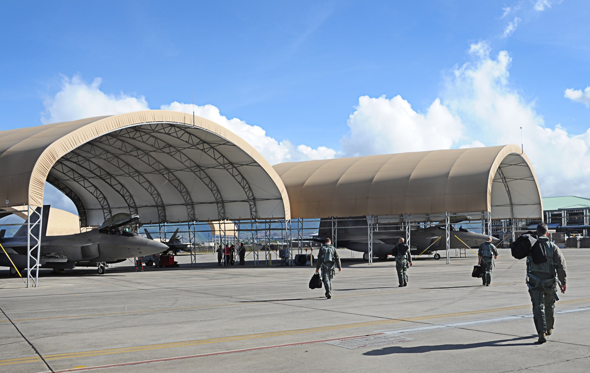 F-22 Raptor pilots head for their aircraft before taking off from Joint Base Pearl Harbor-Hickam, Hawaii, during an Initial Operational Capability (IOC) certification Nov. 8. The Raptor performs both air-to-air and air-to-ground missions allowing full realization of operational concepts vital to the 21st century Air Force. (U.S. Air Force photo/Senior Airman Lauren Main)