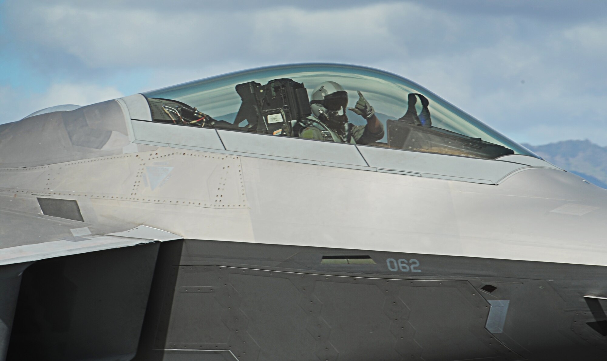 An F-22 Raptor pilot gives the "shakka" as he taxis for takeoff from Joint Base Pearl Harbor-Hickam, Hawaii, during an Initial Operational Capability (IOC) certification Nov. 8. The F-22 possesses a sophisticated sensor suite allowing the pilot to track, identify, shoot and kill air-to-air threats before being detected. (U.S. Air Force photo/Senior Airman Lauren Main)