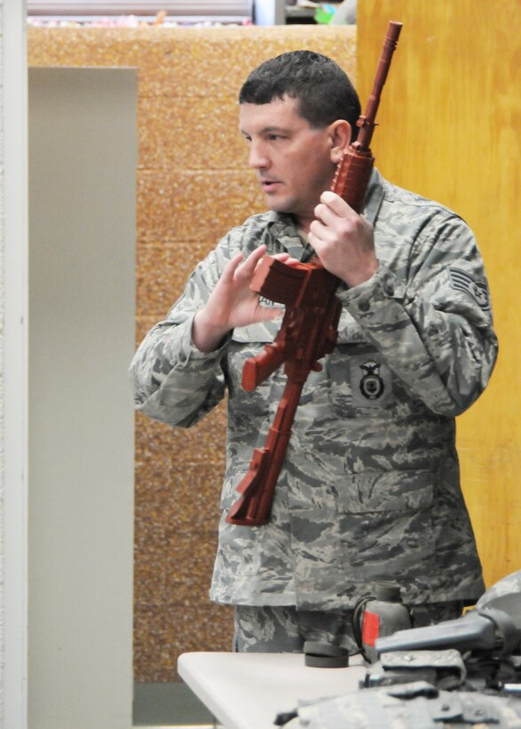 U.S. Air Force Staff Sgt. Brian Willaman, 910th Security Forces member, explains training methods and job requirements using a training weapon as a visual aid for an audience of students and teachers at Poland North Elementary School, Poland, Ohio. Sgt. Willaman, along with Staff Sgt. Arlon Johnson, also a Security Forces member, were guests at the school assembly Nov. 9, 2012, as part of a Veterans Day program. U.S. Air Force photo by Mr. Eric M. White.
