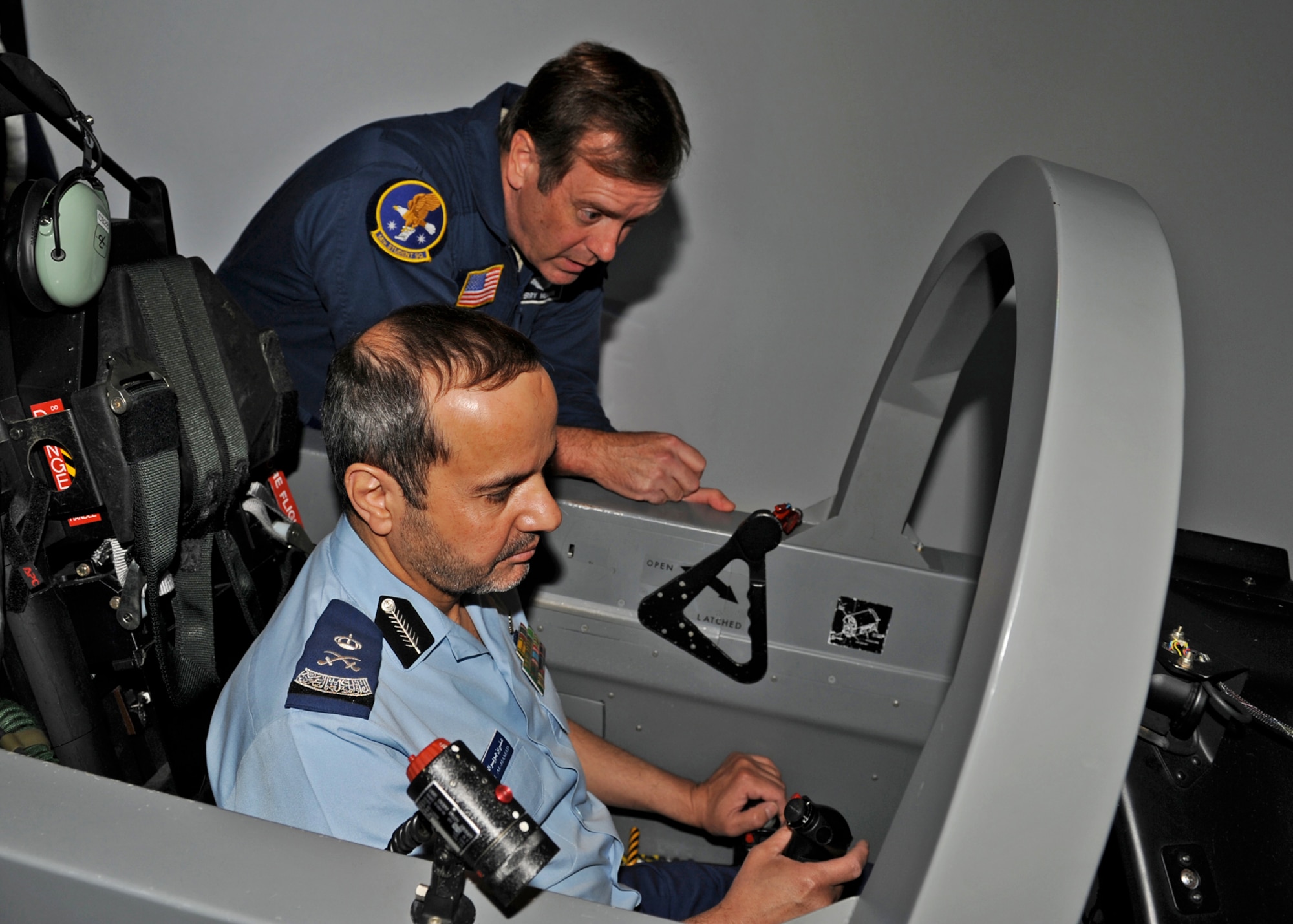 Jim Cucchiara, 14th Student Squadron shows Royal Saudi Air Force Maj. Gen. Ali Bin Juwayr Ali Alhamad, Commander of King Faisal Air Academy around a T-6A Texan II simulator at the 14th Operations Group Building on Nov. 1. Members of the Royal Saudi Air Force visited Columbus Air Force Base Oct. 31 to Nov. 1 to gain a better understanding of the international pilot training program here. (U.S. Air Force photo/Elizabeth Owens)