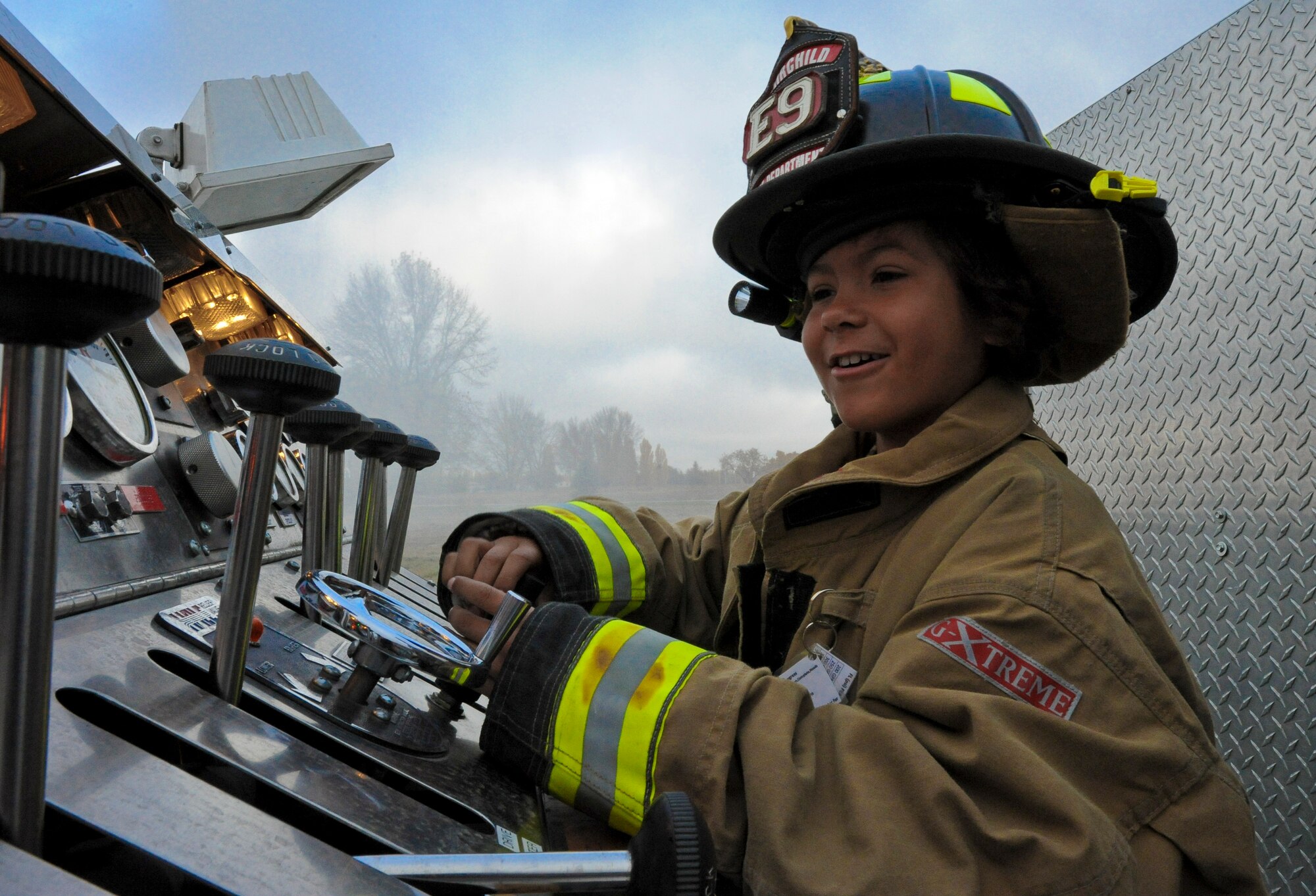 Trevion Worthy mans the controls of a fire truck during his time at the fire department along his journey as ‘Airman for a Day’ at Fairchild Air Force Base, Wash., Nov. 2, 2012. Tre was the second youth to participate in the program at Fairchild that gives children a break from challenges they face on a day-to-day basis. Tre has been fighting Acute Lymphoblastic Leukemia and undergone almost two years of chemo therapy. (U.S. Air Force photo by Senior Airman Benjamin Stratton)