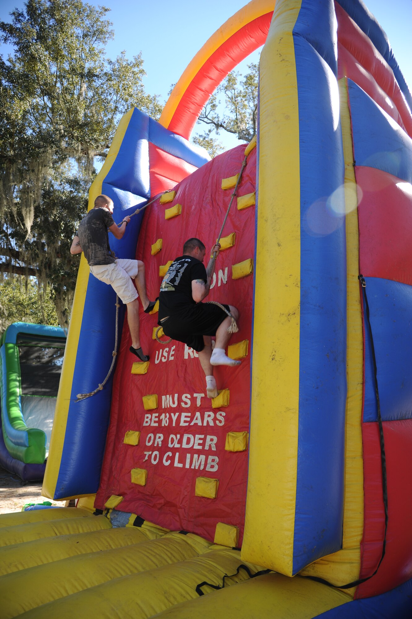 Airman 1st Class Brody Forbes, and Airman Basic Christopher Frietsch, 335th Training Squadron, take advantage of the inflatable rock climb at the consolidated unit inspection celebration picnic Nov. 7, 2012, at the Marina Park, Keesler Air Force Base, Miss.  (U.S. Air Force photo by Kemberly Groue)