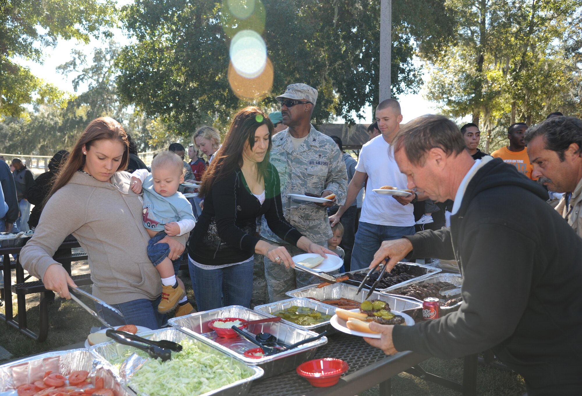 Staff Sgt. Jessica Smialek, 335th Training Squadron, her one-year-old son, Jonah, and her mother-in-law, Stephanie Winegar, join (Col.) Chaplain Wilfred Bristol, 81st Training Wing, and Wayne Fortier, 81st Force Support Squadron, in the food line at the consolidated unit inspection celebration picnic Nov. 7, 2012, at the Marina Park, Keesler Air Force Base, Miss.  (U.S. Air Force photo by Kemberly Groue)