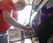 Jim Muir, 902nd Vehicle Management Flight site manager, installs the AIM2 fuel conservation system, Oct. 25 at Joint Base San Antonio-Randolph. (U.S. Air Force photo by Benjamin Faske)
