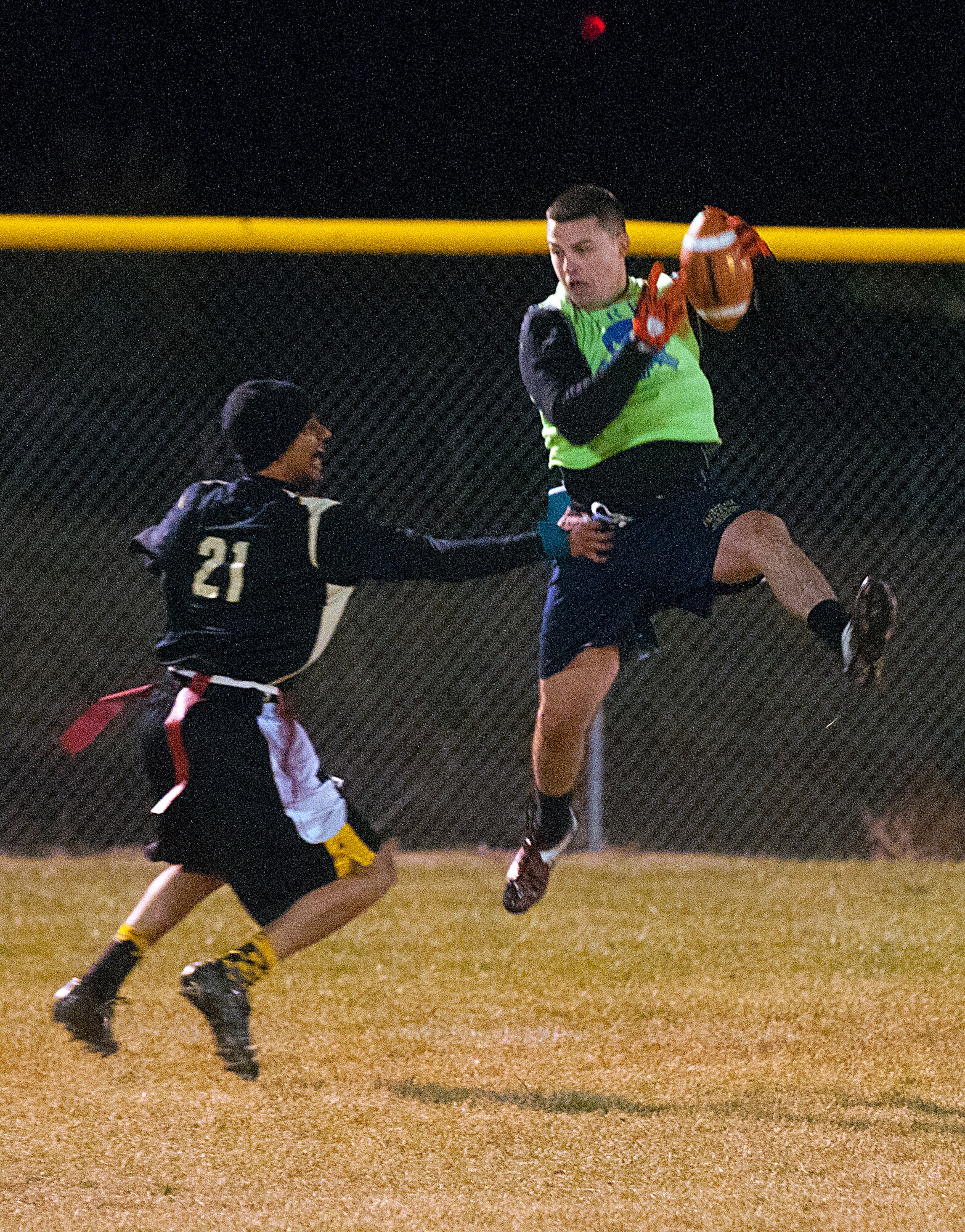 Airman 1st Class Jack Robinette, 90th Security Forces Group Tactical Response Force, pulls down a pass against Senior Airman Corey Rucker, 90th Missile Maintenance Squadron, in the last half of the second game of the F. E. Warren flag football championship Nov. 2. The 90th SFG/TRF won the first game 19 to 6 forcing a second game in the double-elimination tournament. (U.S. Air Force photo by R.J. Oriez)
