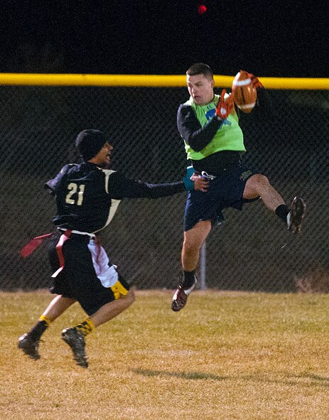 Airman 1st Class Jack Robinette, 90th Security Forces Group Tactical Response Force, pulls down a pass against Senior Airman Corey Rucker, 90th Missile Maintenance Squadron, in the last half of the second game of the F. E. Warren flag football championship Nov. 2. The 90th SFG/TRF won the first game 19 to 6 forcing a second game in the double-elimination tournament. (U.S. Air Force photo by R.J. Oriez)