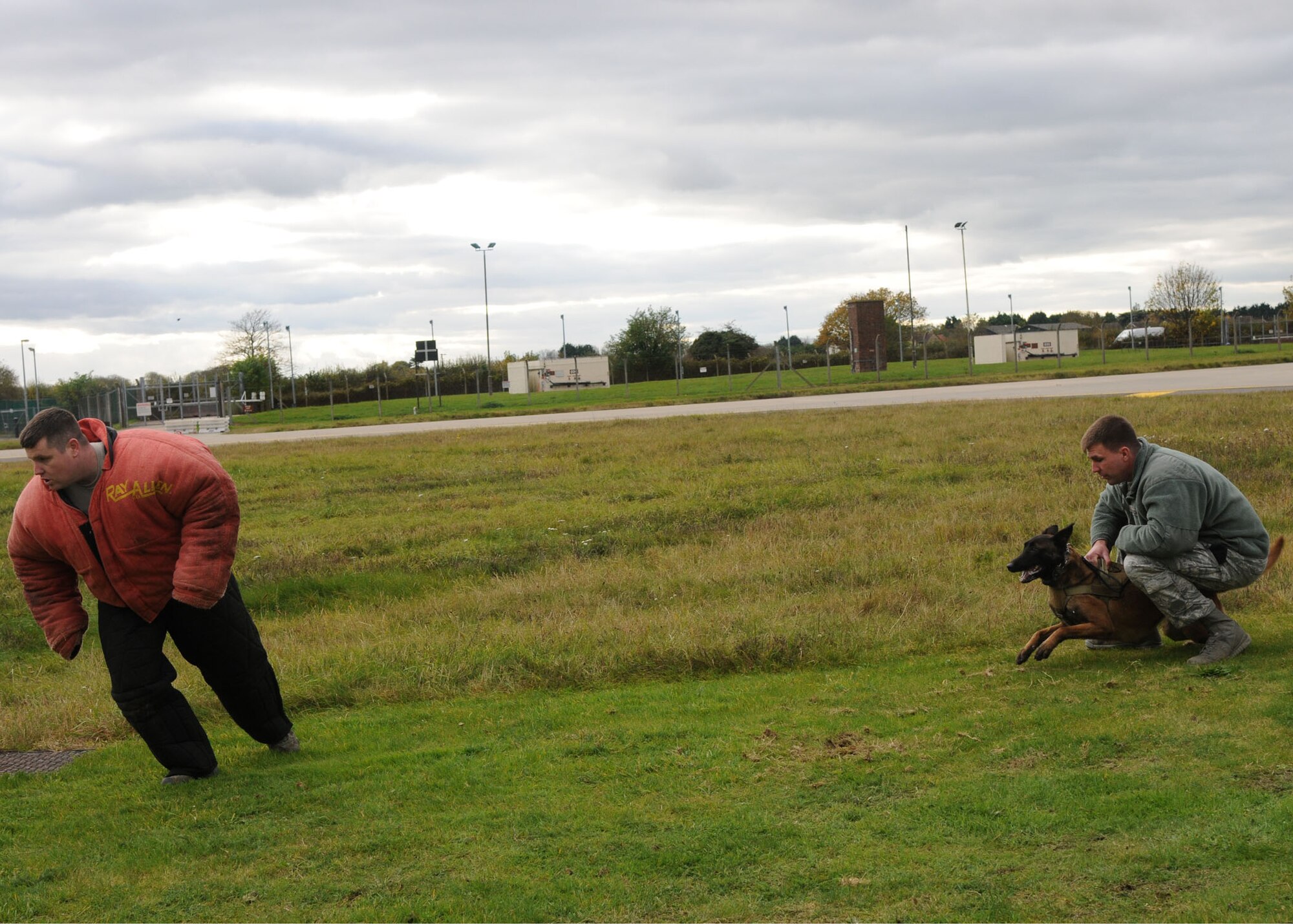 Staff Sgt. Kaylon Pendleton, 100th Security Force Squadron military working dog handler, runs from a military working dog as part of a demonstration during the Honorary Commanders’ Day Nov. 8, 2012, at RAF Mildenhall, England. During Honorary Commanders’ Day, there were job demonstrations and briefings that showcased several squadrons on base, allowing honorary commanders to learn more about the mission, vision and priorities of RAF Mildenhall. (U.S. Air Force photo by Airman 1st Class Kelsey Waters/Released)