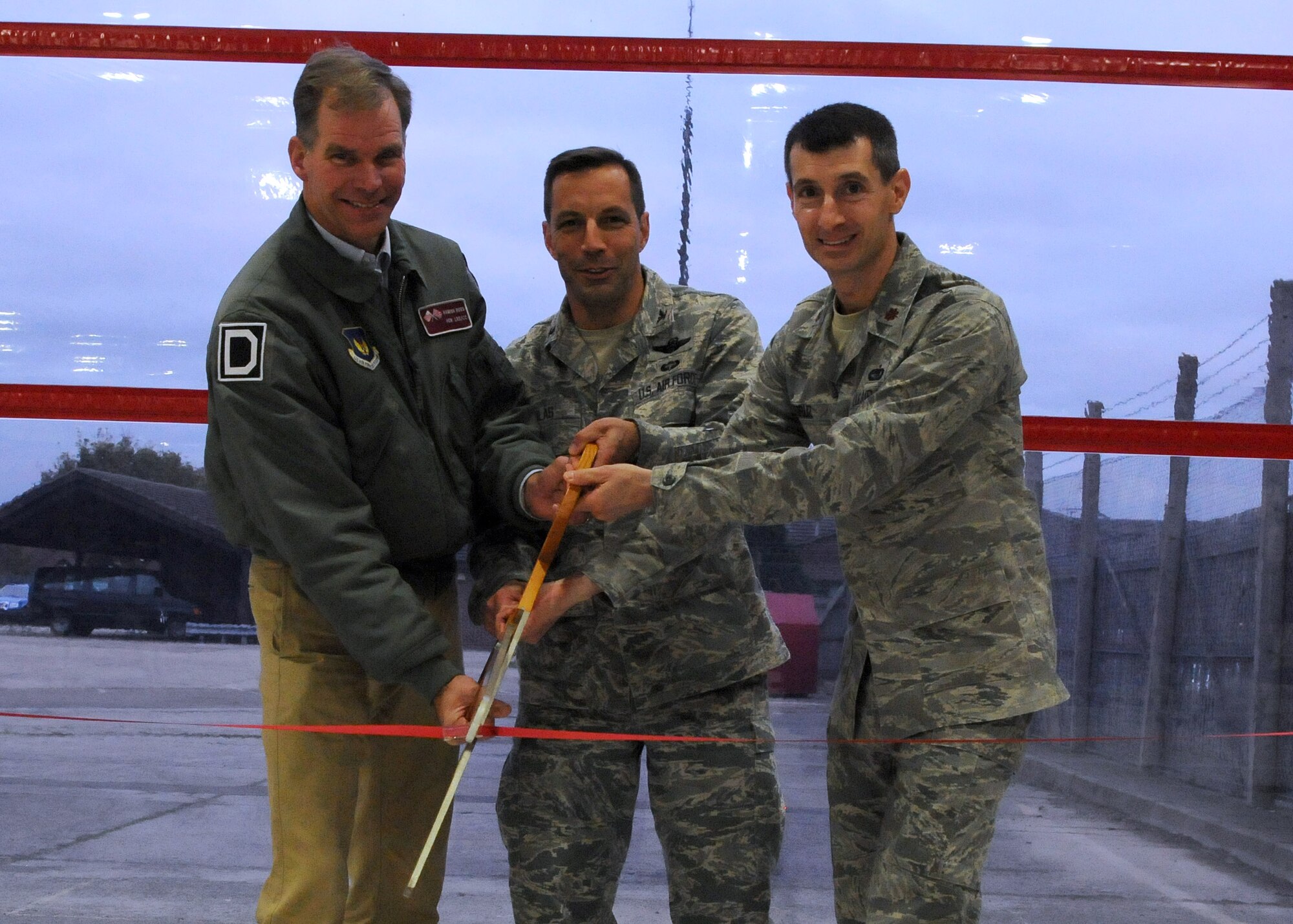 Col. Christopher Kulas, center, 100th Air Refueling Wing commander,  Maj. Timothy Voruz, right, 100th Logistics Readiness Squadron commander, and Hamish Ross, 100th LRS honorary commander, cut a ribbon at the reopening of Building 610 Nov. 8, 2012, at RAF Mildenhall, England. Building 610,  the 100th LRS customer service and vehicle management facility, was recently renovated. (U.S. Air Force photo by Staff Sgt. Tabitha M. Lee/Released)