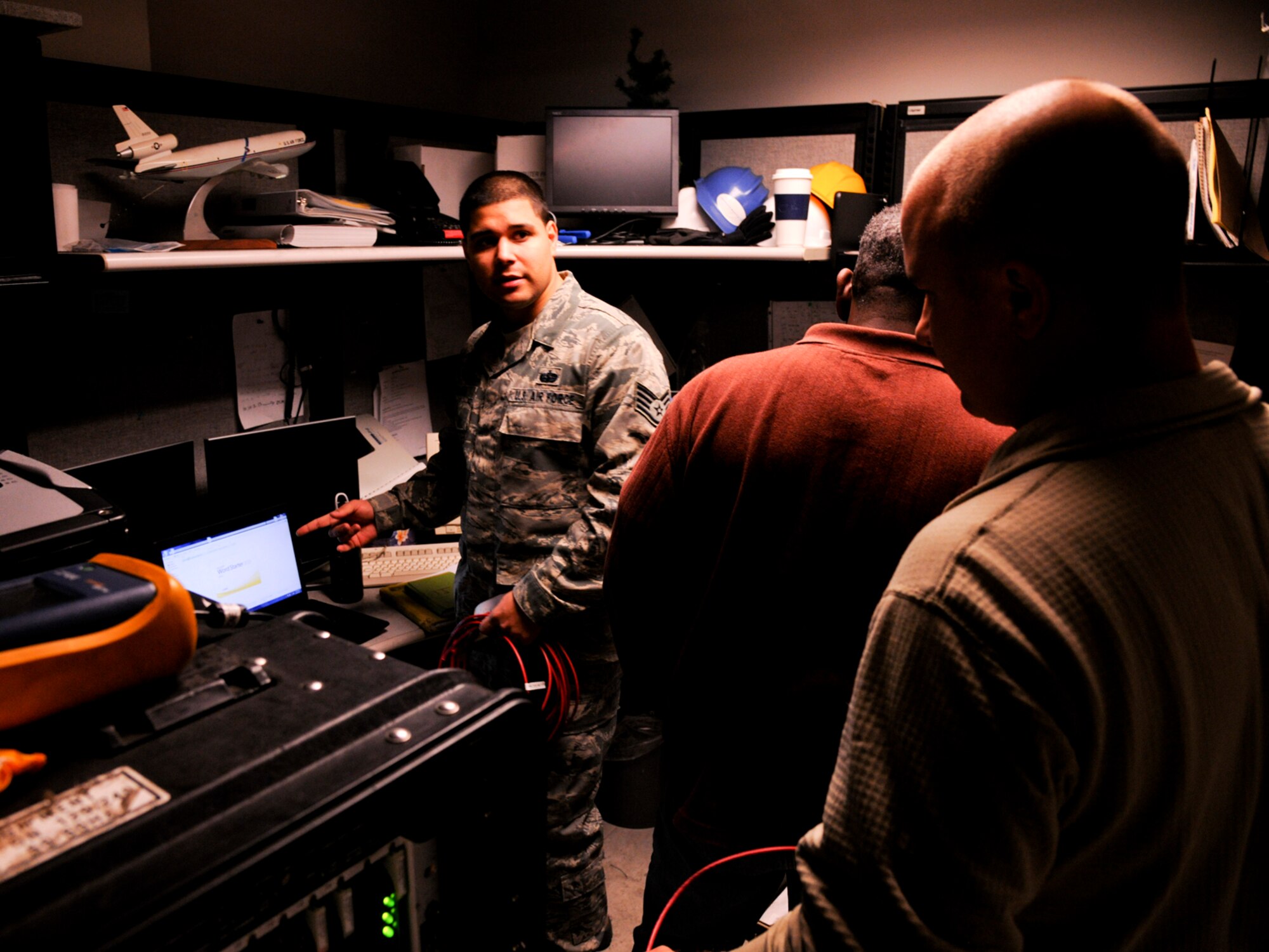 Staff Sgt. Alex Medina, 21st Air Mobility Operations Squadron, discusses the initializing a temporary phone switch with Tech. Sgt. Timothy Majerick, 87th Communications Squadron at the U.S. Air Force Expeditionary Center here Nov. 7. The original switch was destroyed by a power surge during Hurricane Sandy and temporarily disabled all phone service within the Center.  (U.S. Air Force photo by Tech. Sgt. Zachary Wilson/Released.)