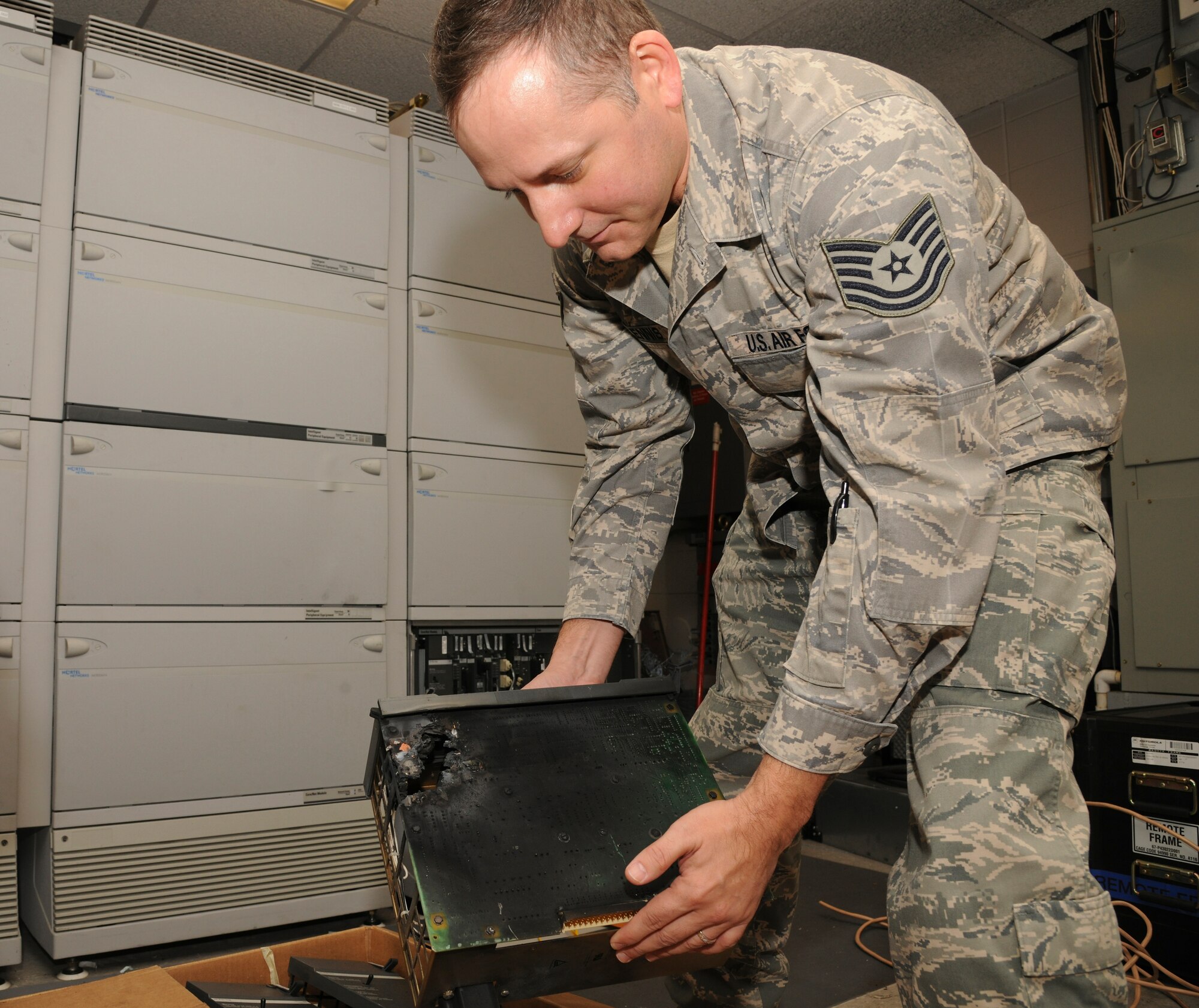 Tech. Sgt. Gary Ennis, 87th Communications Squadron, places a circuit board into a box of other phone switch components that were destroyed after an electrical surge destroyed the U.S. Air Force Expeditionary Center's phone switch at Joint Base McGuire-Dix-Lakehurst, N.J. The surge caused over $1.5 million in damage and will take three to six months to replace. (U.S. Air Force photo by Tech. Sgt. Zachary Wilson/Released.)