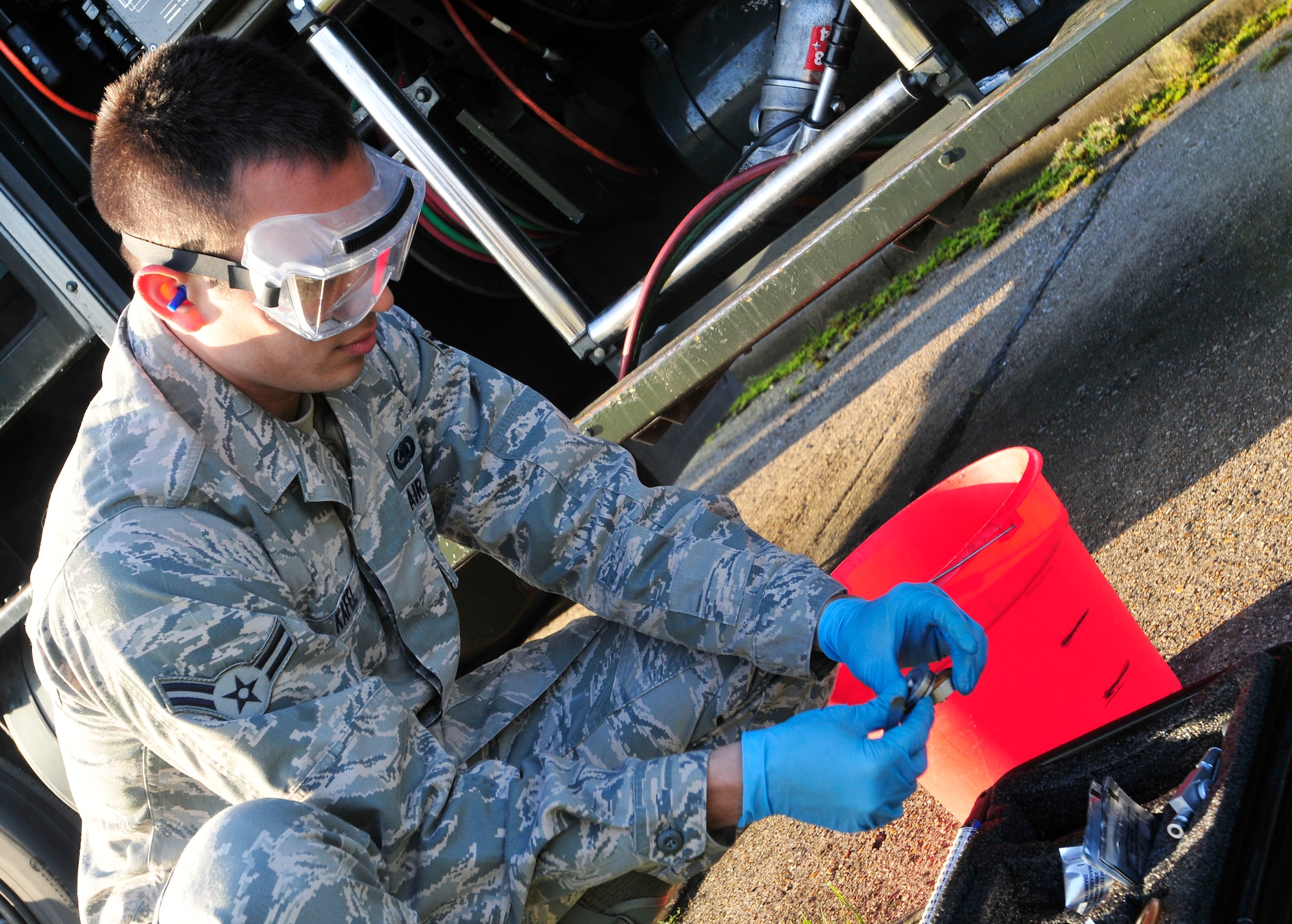 ROYAL AIR FORCE LAKENHEATH, England - Airman 1st Class Christian Kafel, 48th Logistics Readiness Squadron fuels laboratory technician, places an aeronautical engineering laboratory pad inside an inline sampler before running fuel from a fuel truck through in order to test for water Nov. 6, 2012. Kafel was nominated for a Liberty Spotlight because he displays the core value of "Excellence in All We Do." (U.S. Air Force photo by Senior Airman Tiffany M. Grigg)  