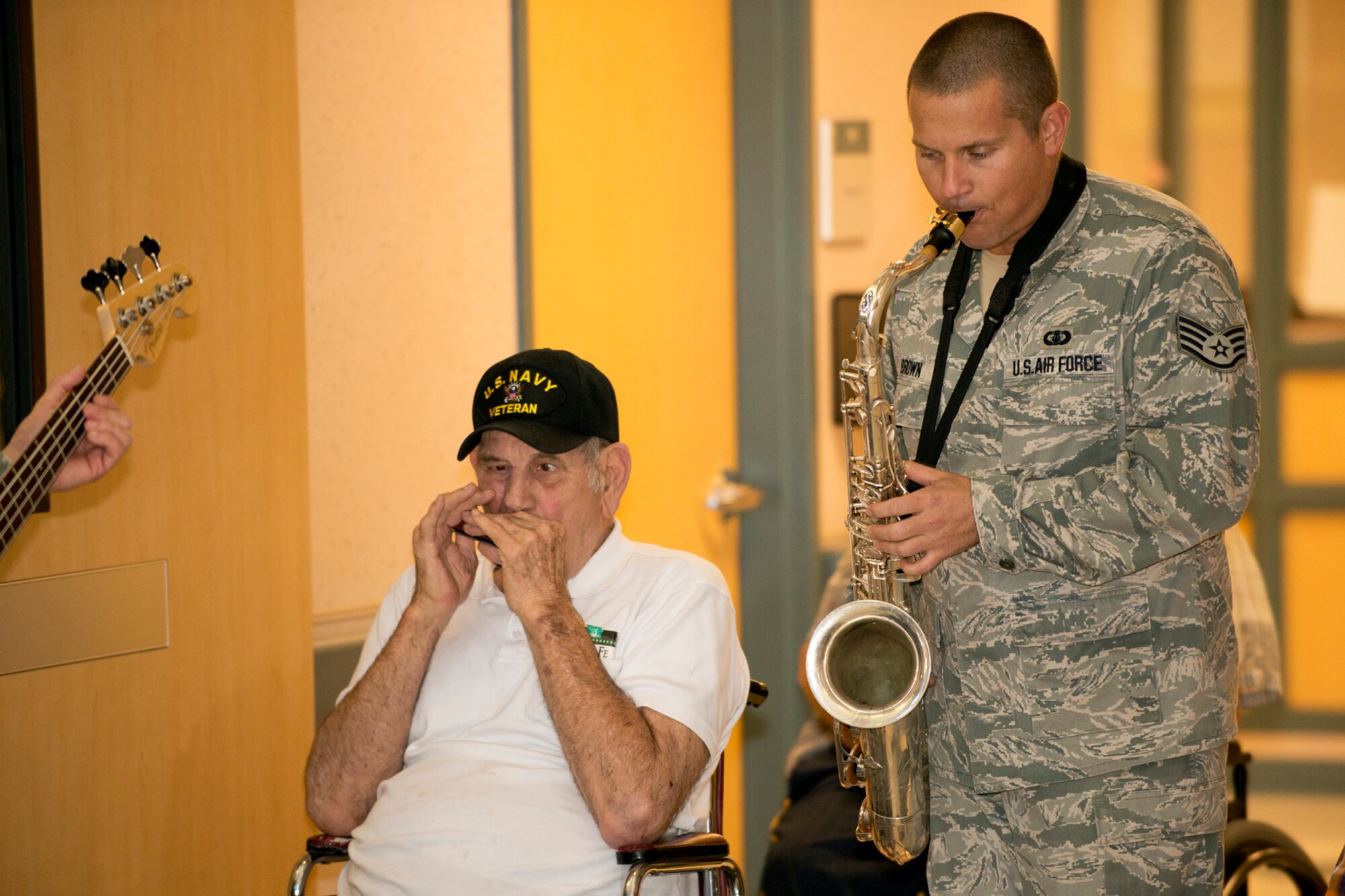 A.J. Bacha, a Korean War veteran, plays along with his harmonica beside Staff Sgt. Cody Brown at the Northwest Louisiana Veterans Home, Nov. 6, 2012, Bossier City, La. Brown is a saxophone player in the U.S. Air Force Band of the West and his ensemble performed at the veterans home. (U.S. Air Force photo by Master Sgt. Greg Steele/Released)