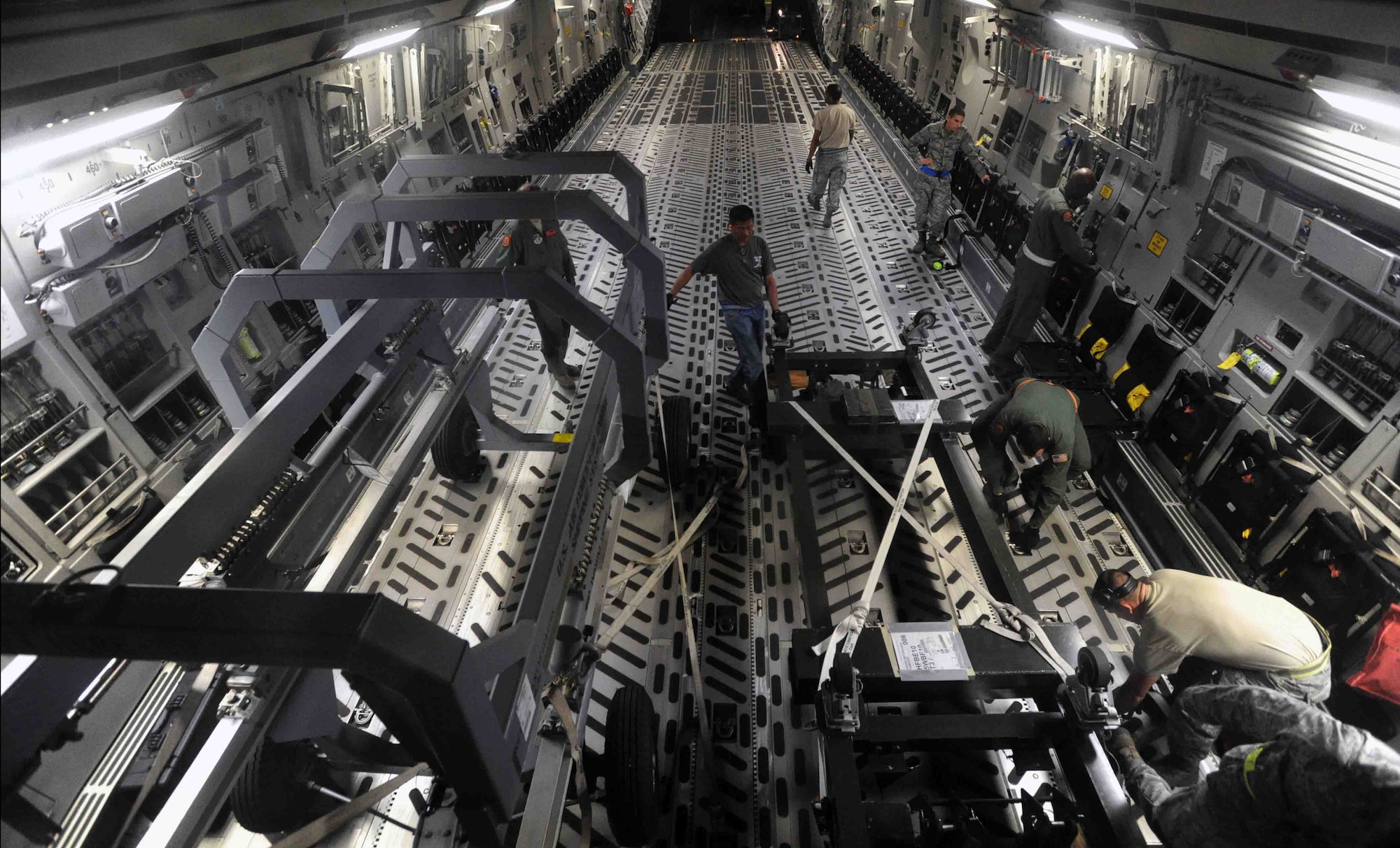 Airmen from the 154th Wing, 15th Wing, and 735th Air Mobility Squadron load items into the cargo bay of a C-17 Globemaster III during a "live load" exercise Nov. 9 at Joint Base Pearl Harbor-Hickam, Hawaii. As part of a Phase I deployment exercise, the live load  simulated one step in a deployment process designed to rapidly deploy Airmen in response to worldwide contingency operations. (U.S. Air Force photo by Staff Sgt. Nathan Allen)