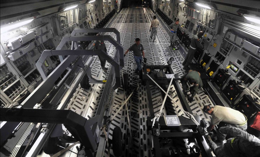 Airmen from the 154th Wing, 15th Wing, and 735th Air Mobility Squadron load items into the cargo bay of a C-17 Globemaster III during a "live load" exercise Nov. 9 at Joint Base Pearl Harbor-Hickam, Hawaii. As part of a Phase I deployment exercise, the live load  simulated one step in a deployment process designed to rapidly deploy Airmen in response to worldwide contingency operations. (U.S. Air Force photo by Staff Sgt. Nathan Allen)