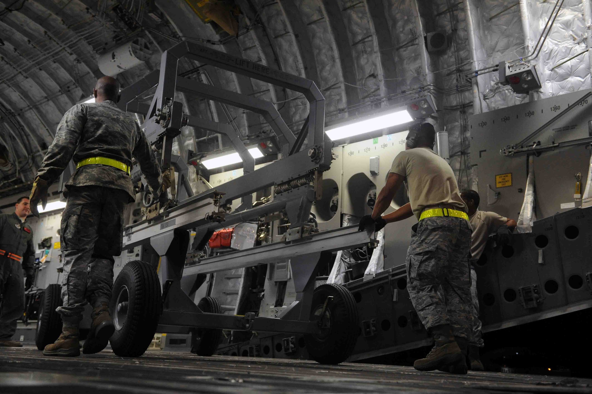 Airmen from the 15th Wing and 735th Air Mobility Squadron load items into the cargo bay of a C-17 Globemaster III during  a "live load" exercise Nov. 9 at Joint Base Pearl Harbor-Hickam, Hawaii. As part of a Phase I deployment exercise, the live load  simulated one step in a deployment process designed to rapidly deploy Airmen in response to worldwide contingency operations. (U.S. Air Force photo by Staff Sgt. Nathan Allen)