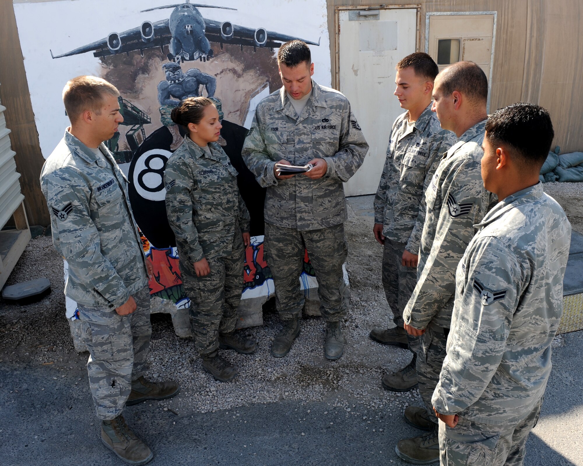 Staff Sgt. Jesse Foor, 8th Expeditionary Air Mobility Squadron aerial port expeditor, goes over the details of a load plan with his ramp services crew Nov. 9, 2012. The aerial port expeditor is responsible for the proper delivery of cargo on the aircraft along with the day-to-day supervisory roles of the ramp services crew. As part of those duties, the expeditor has to translate and communicate the load plan to his ramp services team and have a comprehensive understanding of a proper load balance. Foor is deployed from the 436th Aerial Port Squadron at Dover Air Force Base, Del., and is a native of Bedford, Pa. (U.S. Air Force photo/Senior Airman Joel Mease)