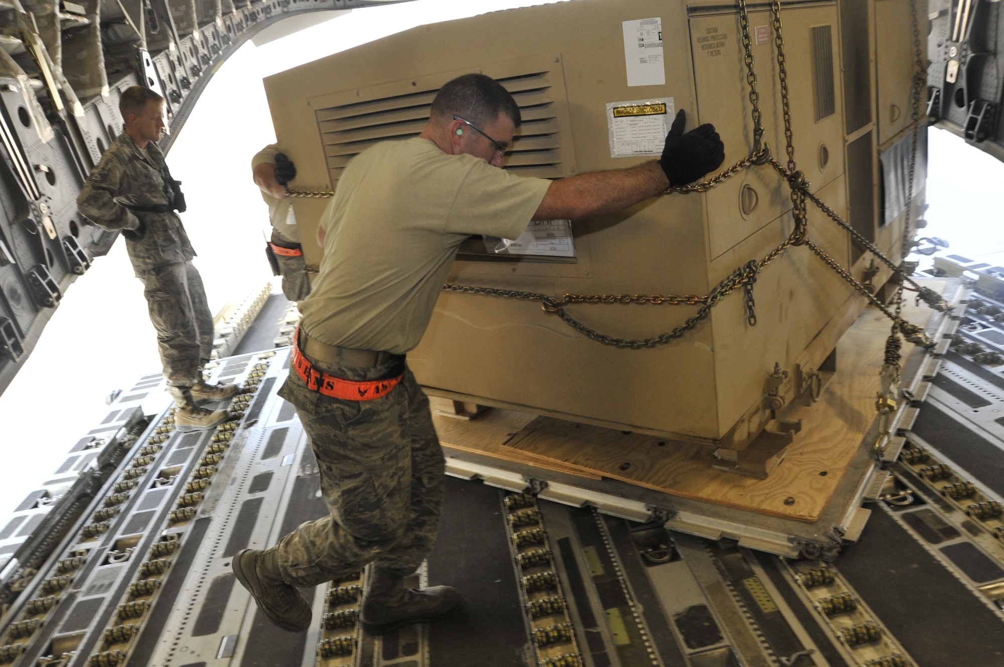 Staff Sgt. Ryan Stoks, 8th Expeditionary Aerial Maintenance Squadron aerial port expeditor, leads the ramp services team in loading cargo onto a C-17 Globemaster III Nov. 7, 2012. Stoks is one of only four aerial port expeditors for the 8th Expeditionary Aerial Maintenance Squadron stationed at the 379th Air Expeditionary Wing. Expeditors are on call 24/7 when not working and provide aircrew member with more crew rest time and the ability to focus on missions. Stoks is deployed from the 62nd Aerial Port Squadron at Joint Base Lewis-McChord, Wash., and is a native of Porter, Minn.  (U.S. Air Force photo/Senior Airman Bryan Swink)