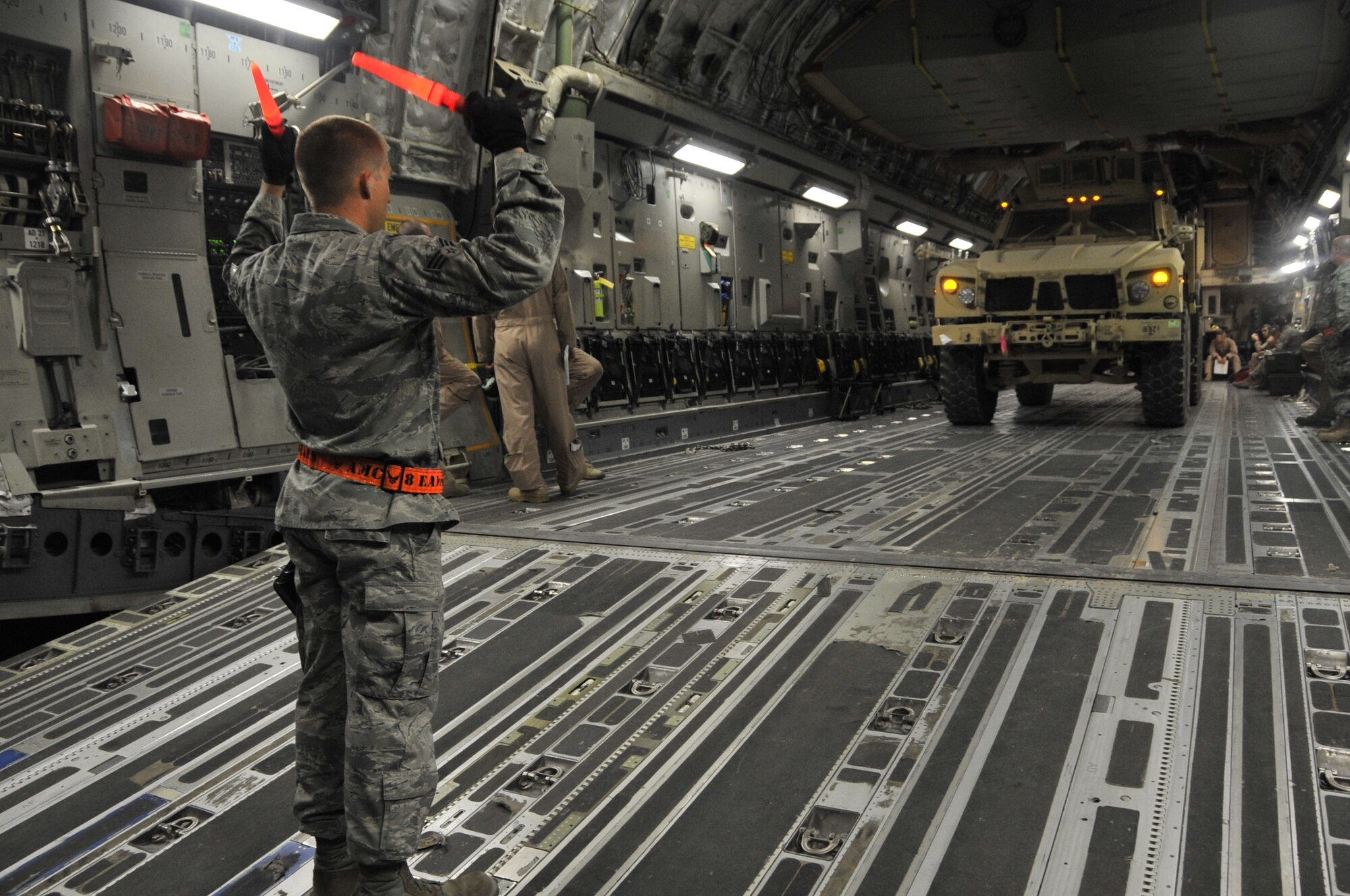 Senior Airman Christopher Brandenburgh, 8th Expeditionary Aerial Maintenance Squadron aerial port expeditor, marshals a mine resistant ambush protected vehicle off a C-17 Globemaster III onto the ramp Nov. 6, 2012. Similar to how an air traffic controller directs plane movement, the aerial port expeditor has to direct the ramp services team as they load or unload cargo to ensure it is done safely and meets all requirements for the flight. Brandenburgh is deployed from the 721st Aerial Port Squadron at Ramstein Air Base, Germany, and is a native of Dunedin, Fla. (U.S. Air Force photo/Senior Airman Bryan Swink)
