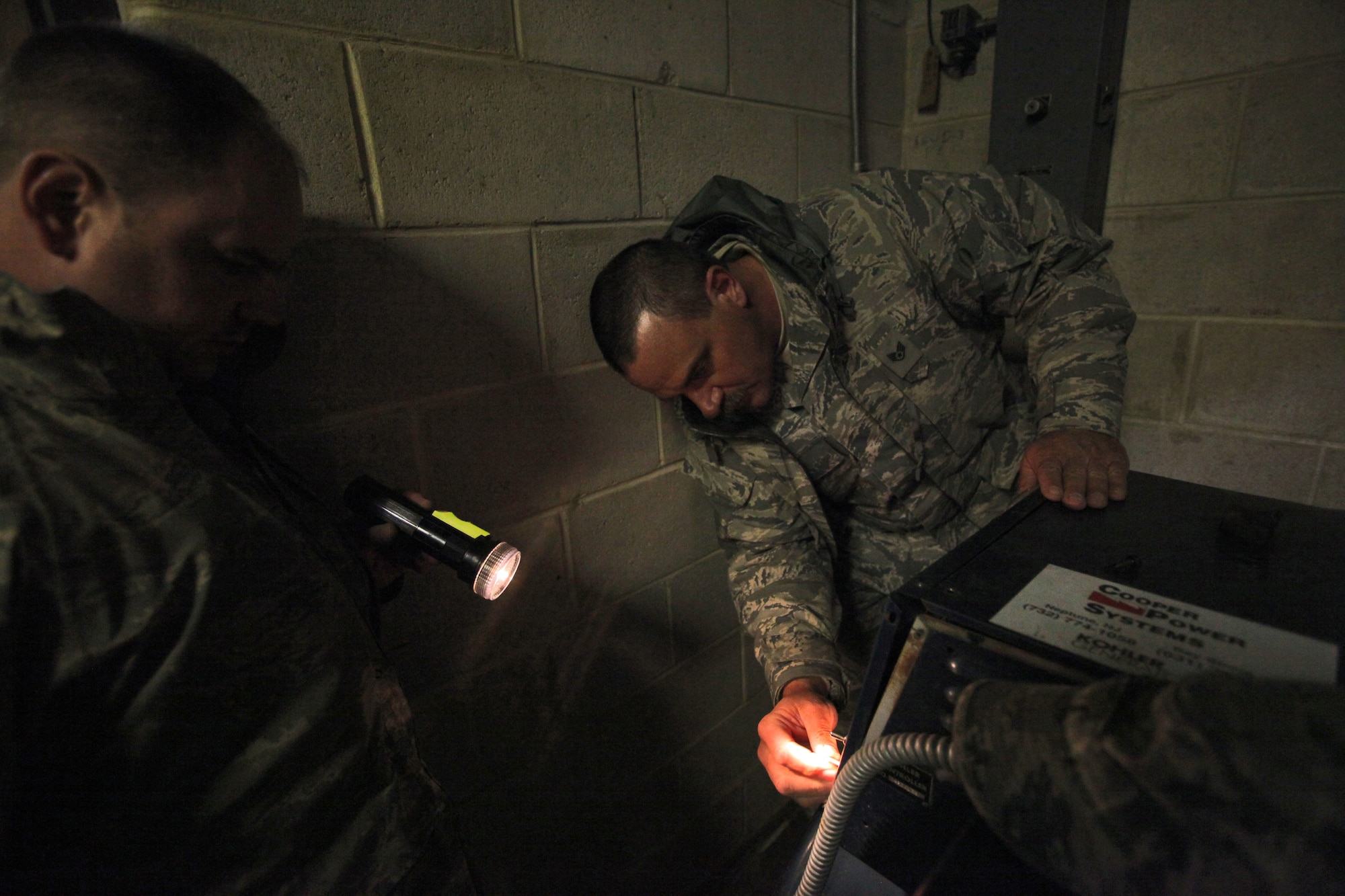Staff Sgt. Robert Jentsch, left, shines a flashlight onto the control panel of a gas-fired generator for Staff Sgt. Carl Hilpl, both with 108th Wing, New Jersey Air National Guard, as Hilpl prepares to start the system so the shelter at Veterans Memorial Middle School in Brick, N.J. will have power Nov. 7, 2012. More than 2,000 Airmen and soldiers from the New Jersey National Guard have been mobilized in response to Hurricane Sandy. (U.S. Air Force photo by Master Sgt. Mark C. Olsen/Released)
