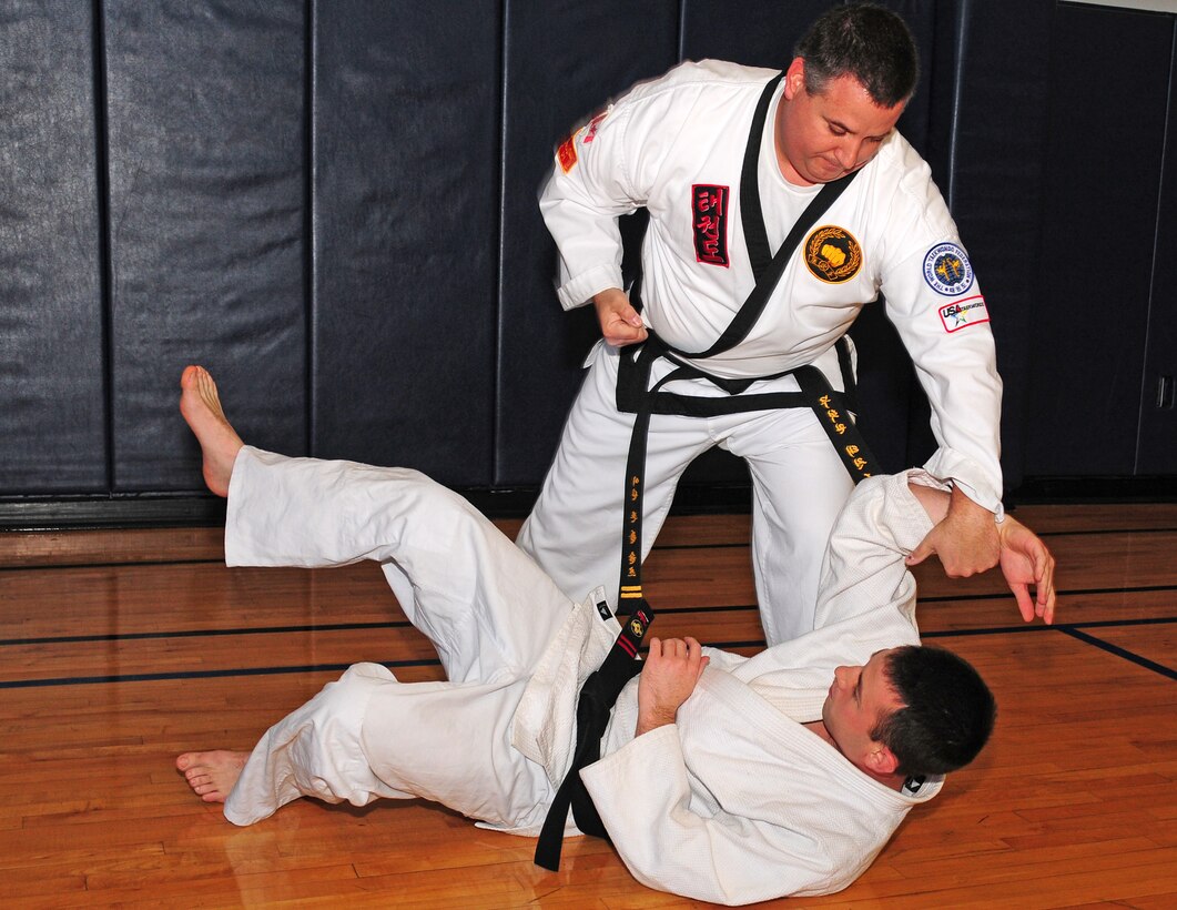 Mr. John Schultz, Fire Inspector for the 914th Fire Emergency Services Flight and Senior Airman Dillon Pinkham, 914th Vehicle Maintenance, demonstrate  self-defense moves at the gym at Niagara Falls Air Reserve Station. Both are self-defense instructors.  Mr. Schultz teaches Taekwondo and Senior Airman Pinkham is a Judo instructor. They have recently combined efforts to teach self defense to members of the Wing and their family members. Taekwondo classes are held at the base gym Monday and Wednesday evenings, from 4:30-5:30pm. (U.S. Air Force photo by Tech. Sgt. Ian Carrier)