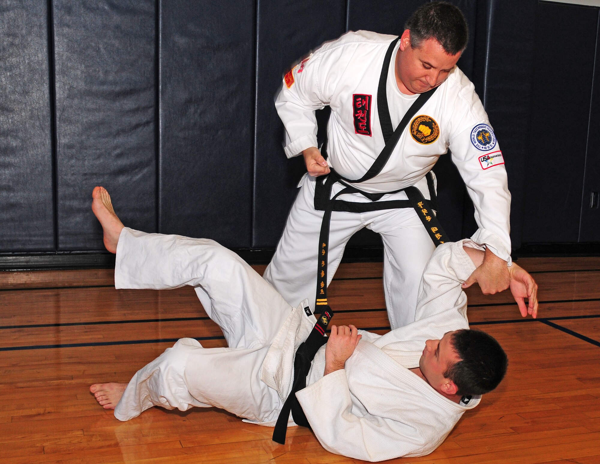 Mr. John Schultz, Fire Inspector for the 914th Fire Emergency Services Flight and Senior Airman Dillon Pinkham, 914th Vehicle Maintenance, demonstrate  self-defense moves at the gym at Niagara Falls Air Reserve Station. Both are self-defense instructors.  Mr. Schultz teaches Taekwondo and Senior Airman Pinkham is a Judo instructor. They have recently combined efforts to teach self defense to members of the Wing and their family members. Taekwondo classes are held at the base gym Monday and Wednesday evenings, from 4:30-5:30pm. (U.S. Air Force photo by Tech. Sgt. Ian Carrier)