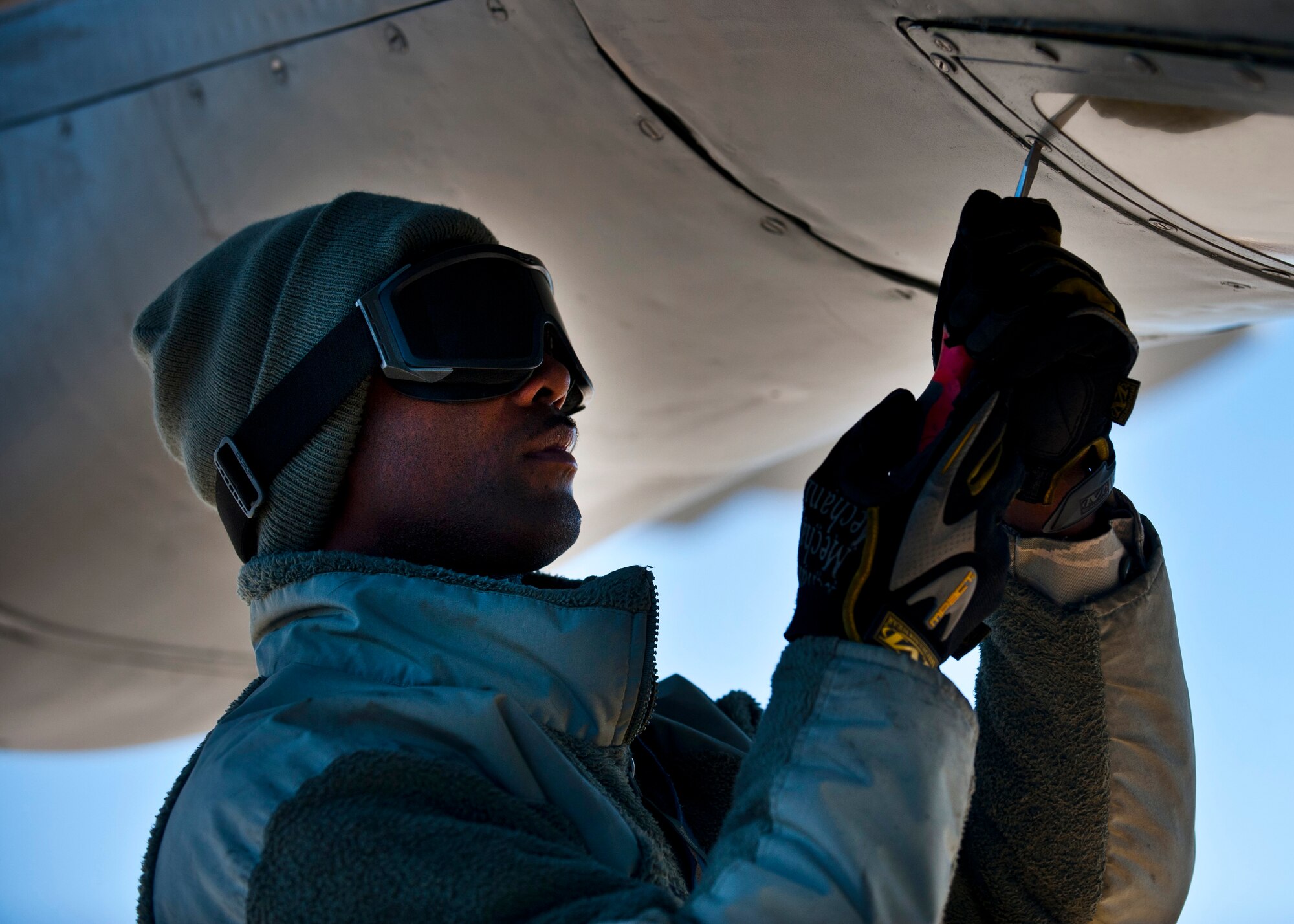 Staff Sgt. Carlos Mitchell loosens screws to service the boom window of a KC-135 Stratotanker at the Transit Center at Manas, Kyrgyzstan, Nov. 8, 2012. Crew chiefs inspect the external part of the aircraft for structural damage. Mitchell is a 376th Expeditionary Aircraft Maintenance Squadron crew chief who is deployed from McConnell Air Force Base, Kan., and a native of Columbia, S.C. (U.S. Air Force photo/Senior Airman Brett Clashman)