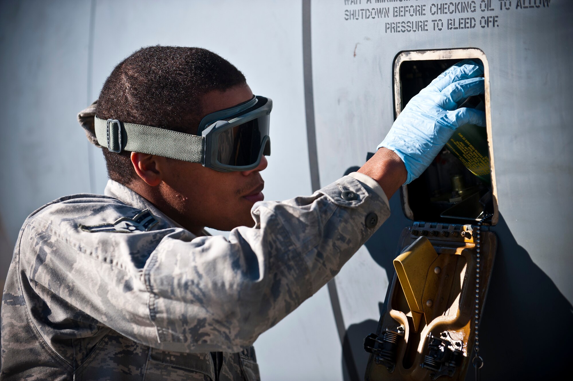 Airman 1st Class Monquavious Johnson adds oil to one of the KC-135 Stratotanker engines at the Transit Center at Manas, Kyrgyzstan, Nov. 8, 2012. Crew chiefs are responsible for the maintenance of the aircraft and support equipment. Johnson is a 376th Expeditionary Aircraft Maintenance Squadron crew chief who is deployed from MacDill Air Force Base, Fla., and a native of Atlanta. (U.S. Air Force photo/Senior Airman Brett Clashman)